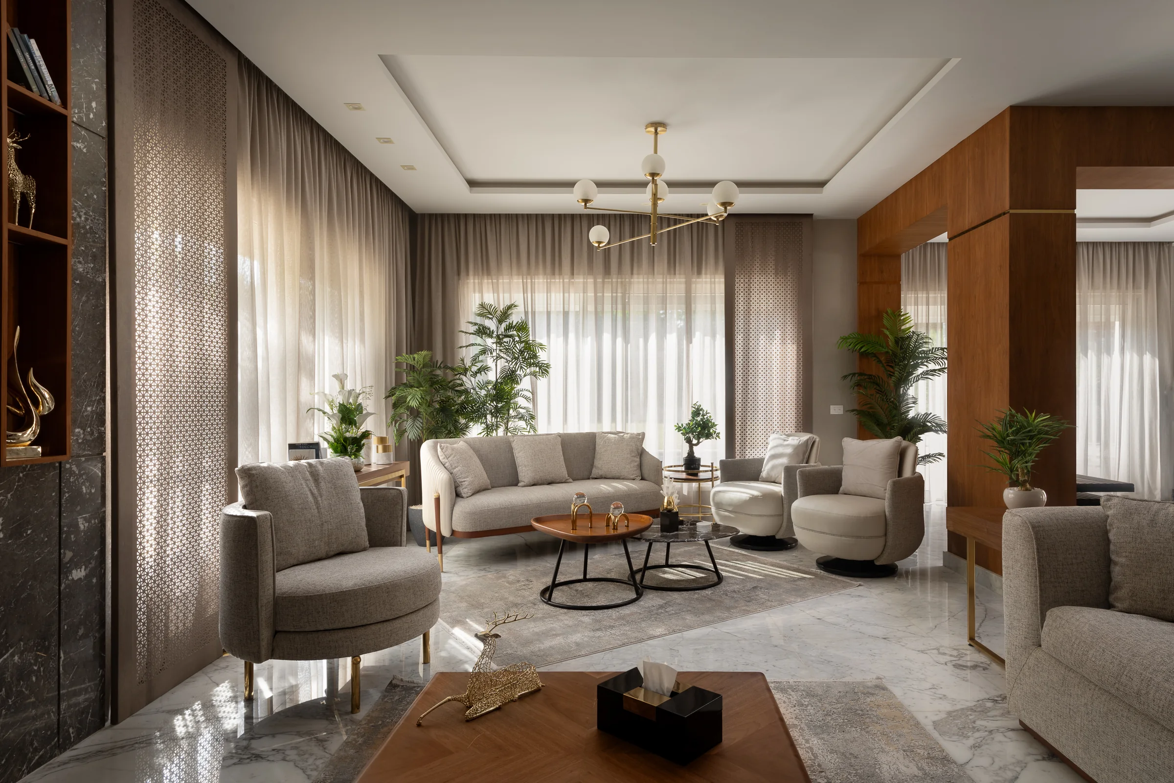 Living room under a brass chandelier, marble and walnut throughout.