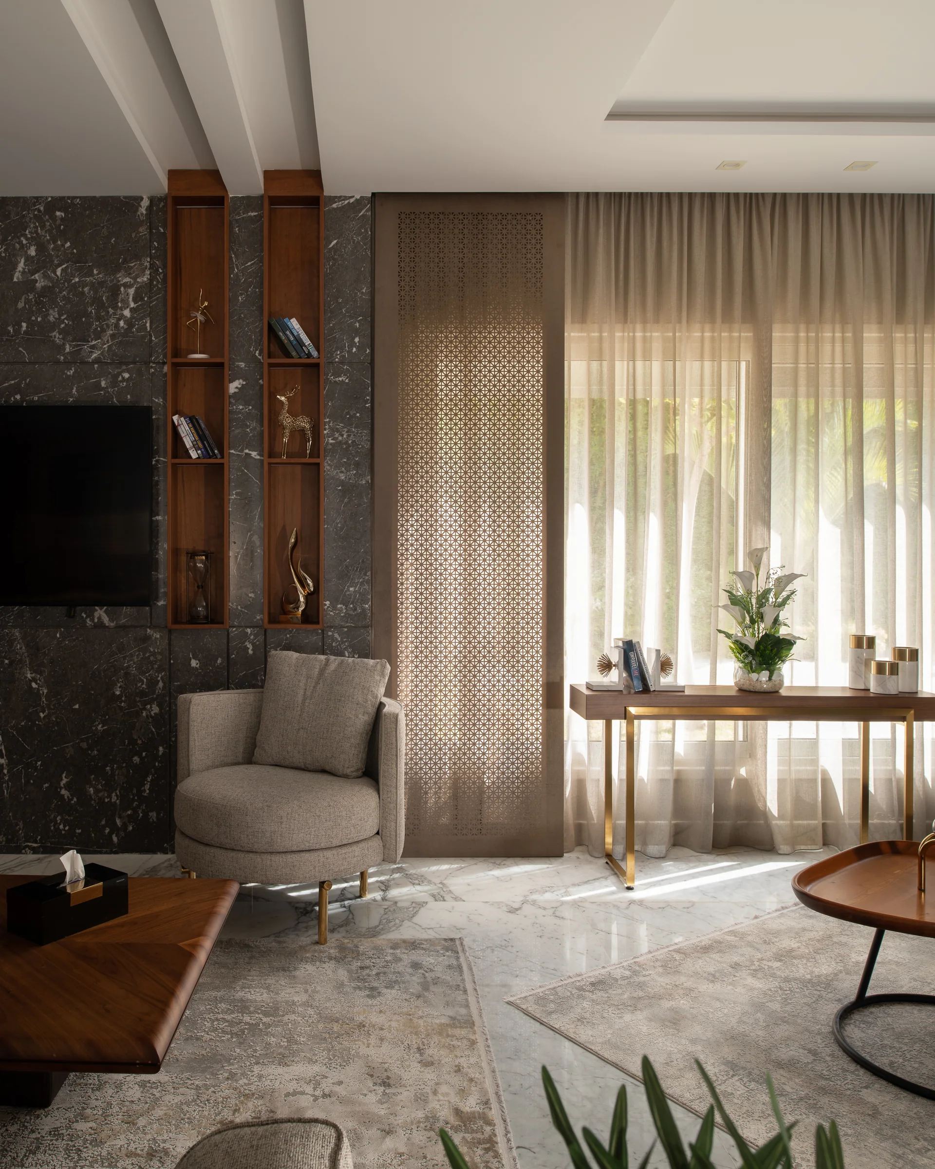 Television wall in grey marble with brass shelving.