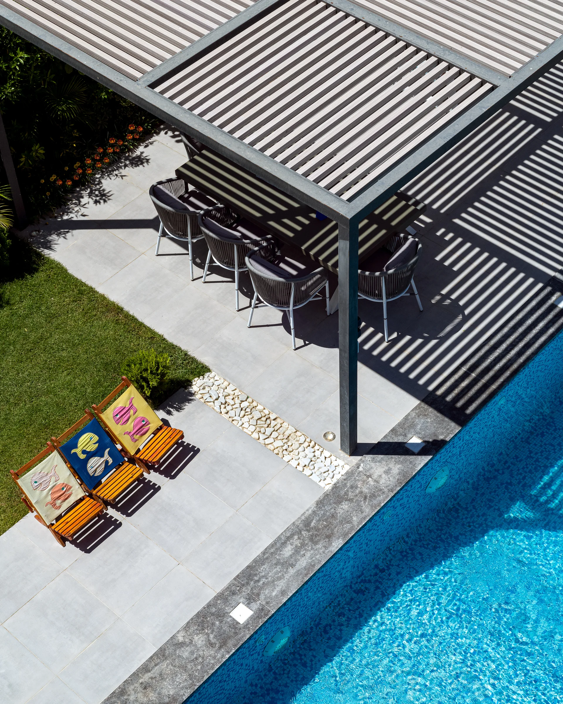 Pergola shadows falling across the terrace and the water.