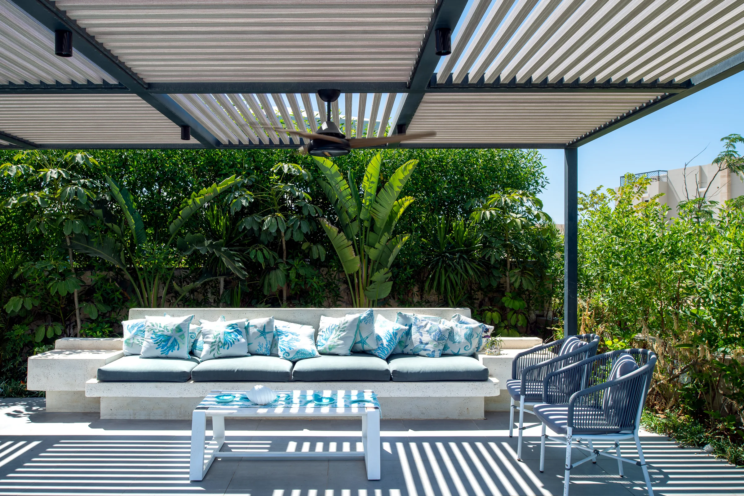 Outdoor sofa under the pergola, planting closing the boundary.