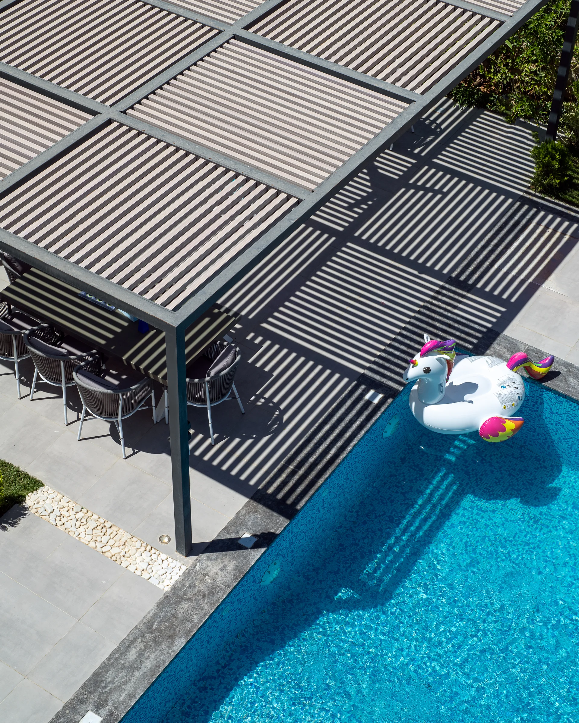 Pool corner with the pergola shadow on the water.