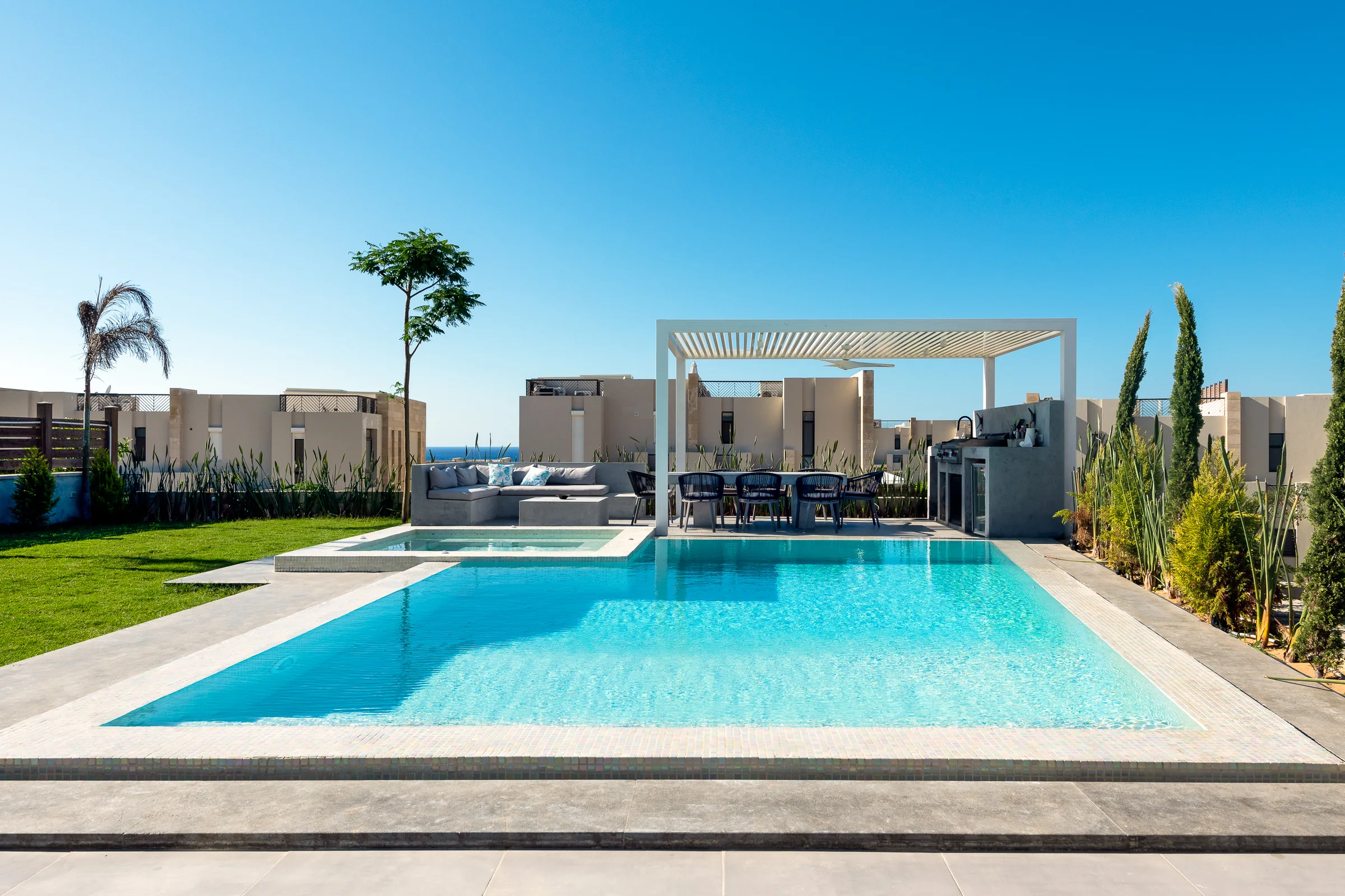 Pool and pergola by day, the development beyond.