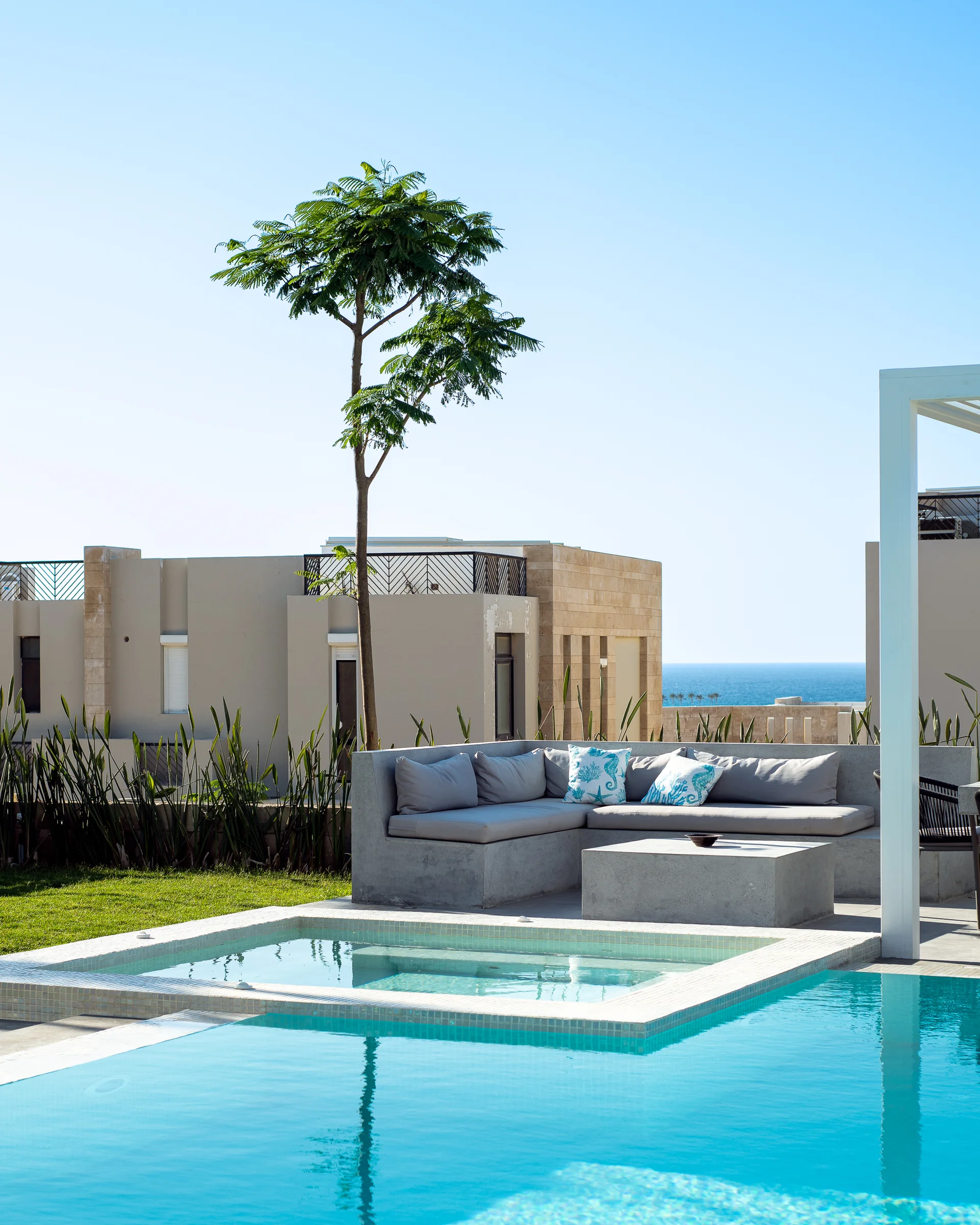 Seating by the water with the sea past the houses.