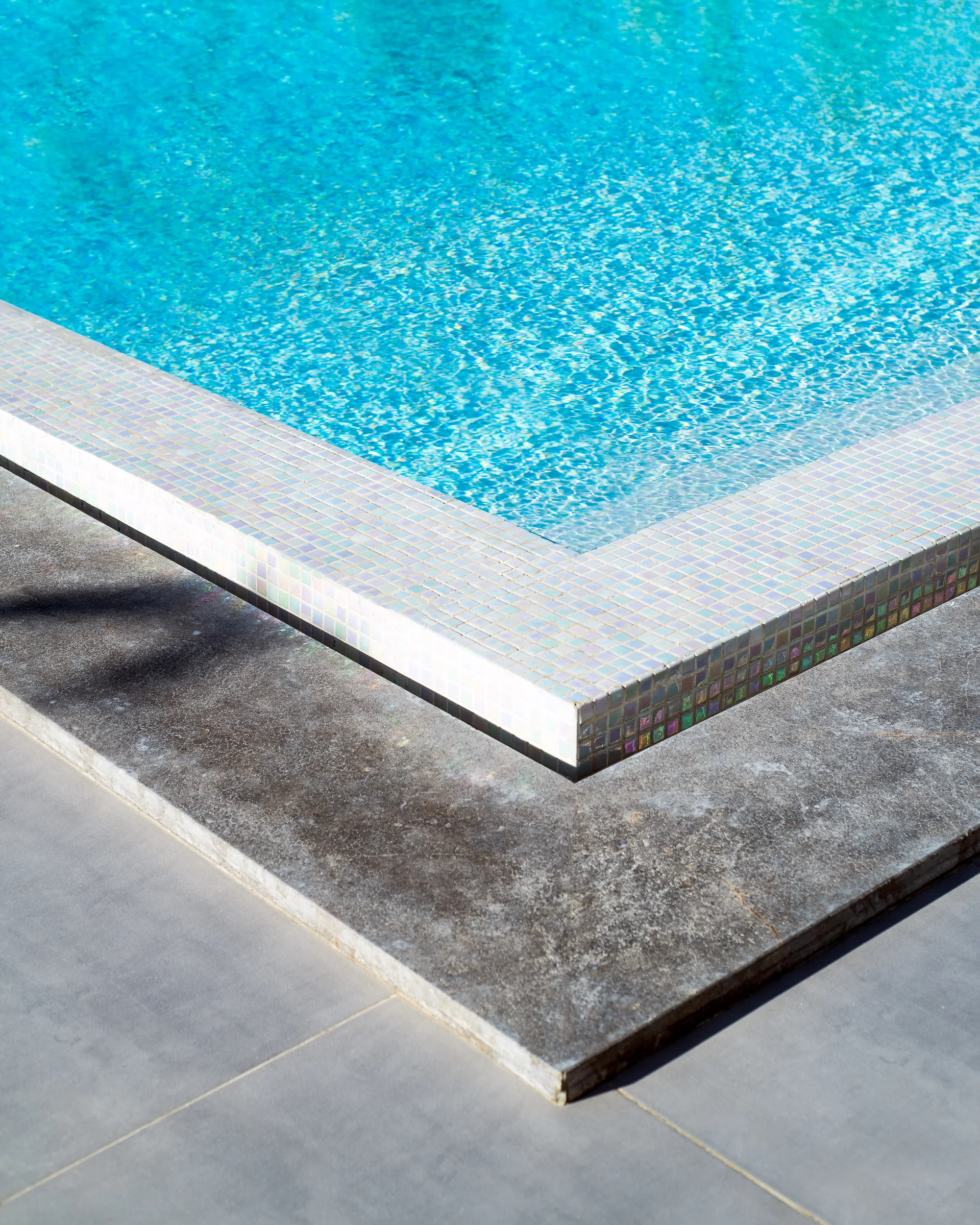 Detail: the pool lip where stone meets water.