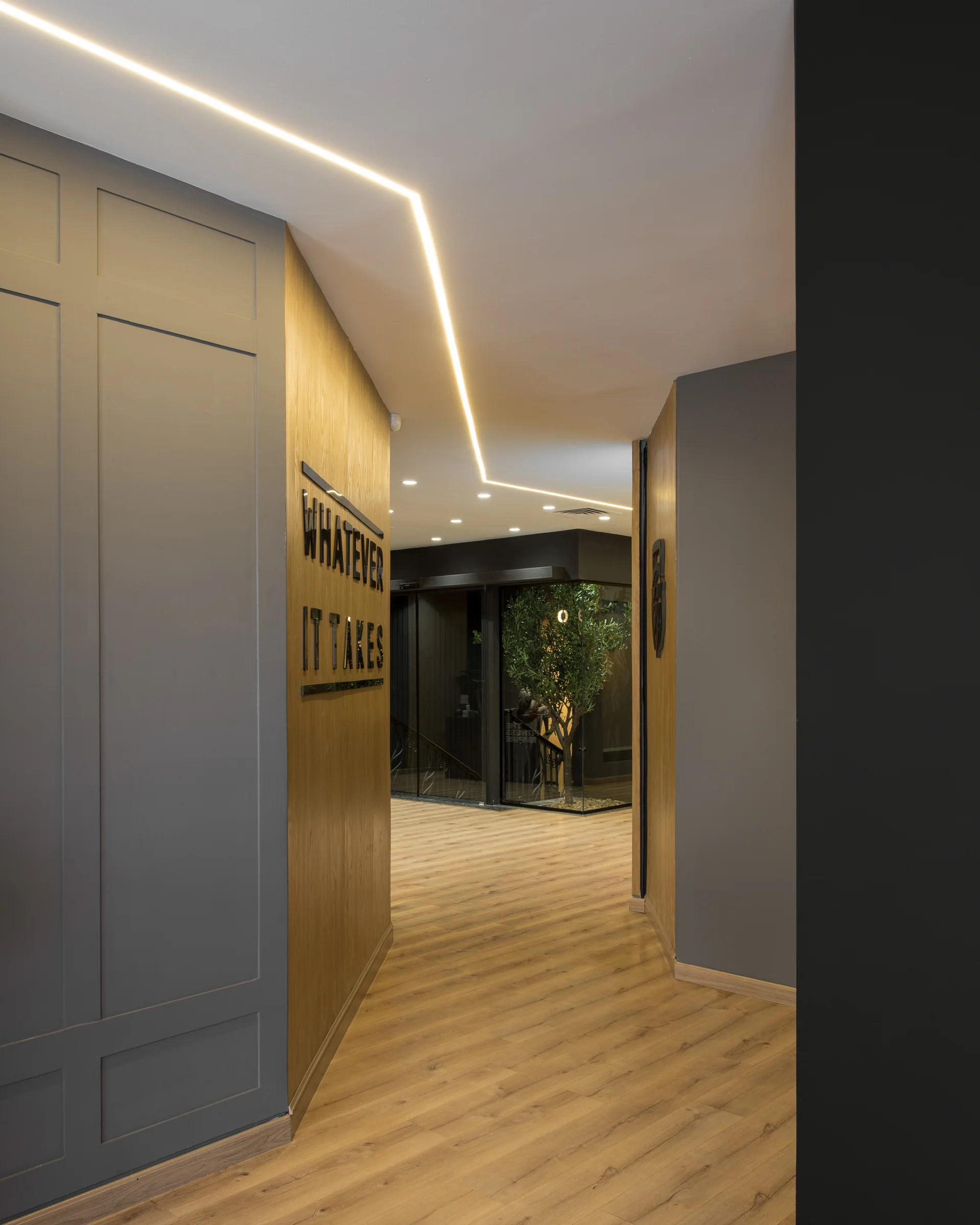 Corridor with a warm cove light along the oak wall.