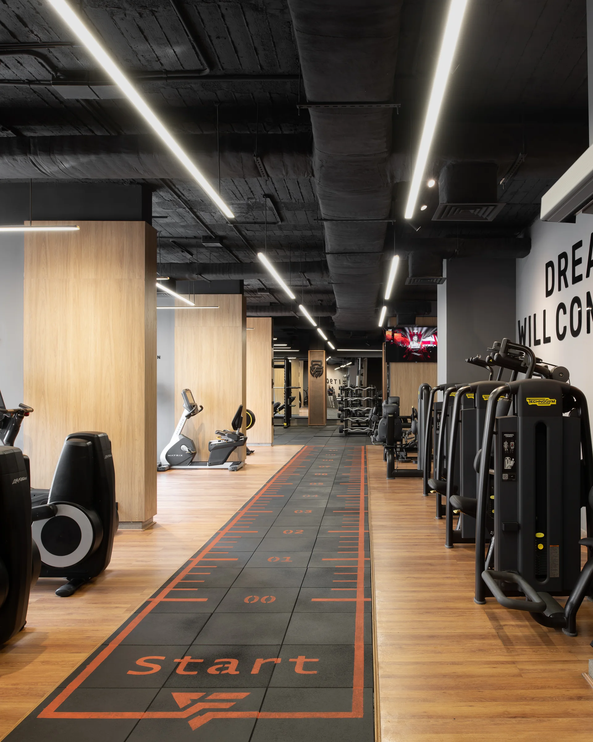Row of upright bikes over the printed running track.