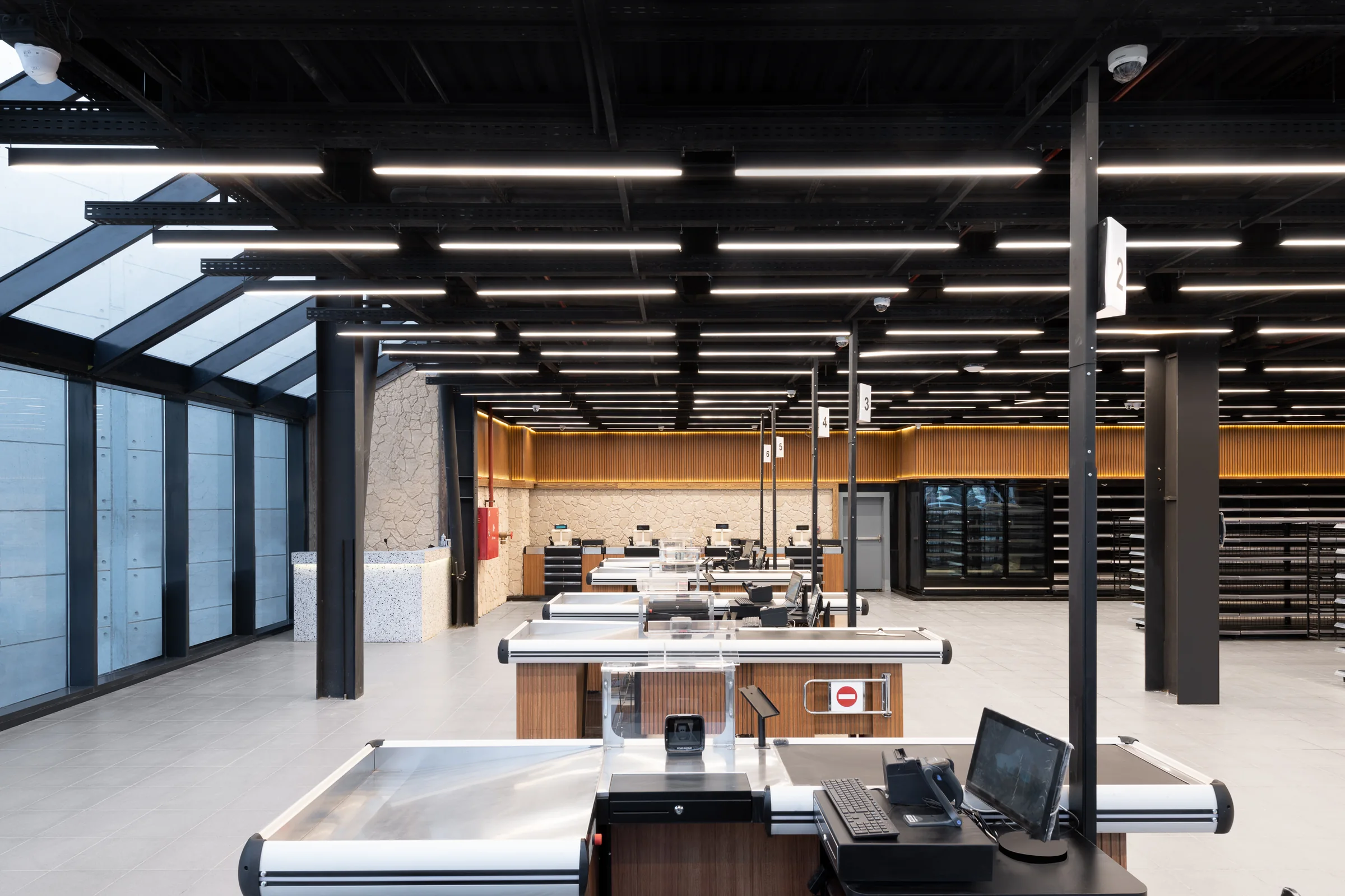 The entry hall under the exposed steel ceiling, tills to the right.