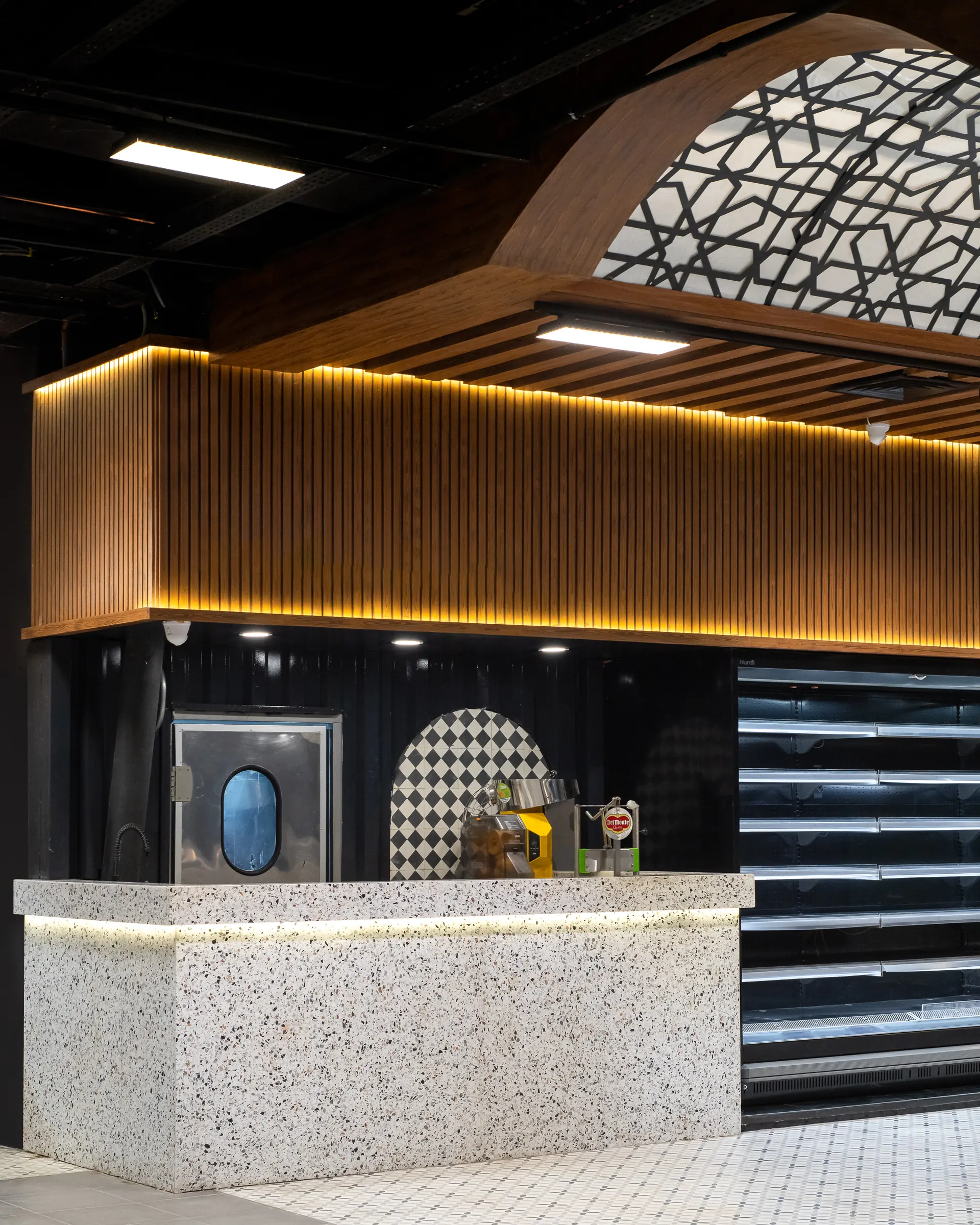 Terrazzo counter under a fluted timber canopy.