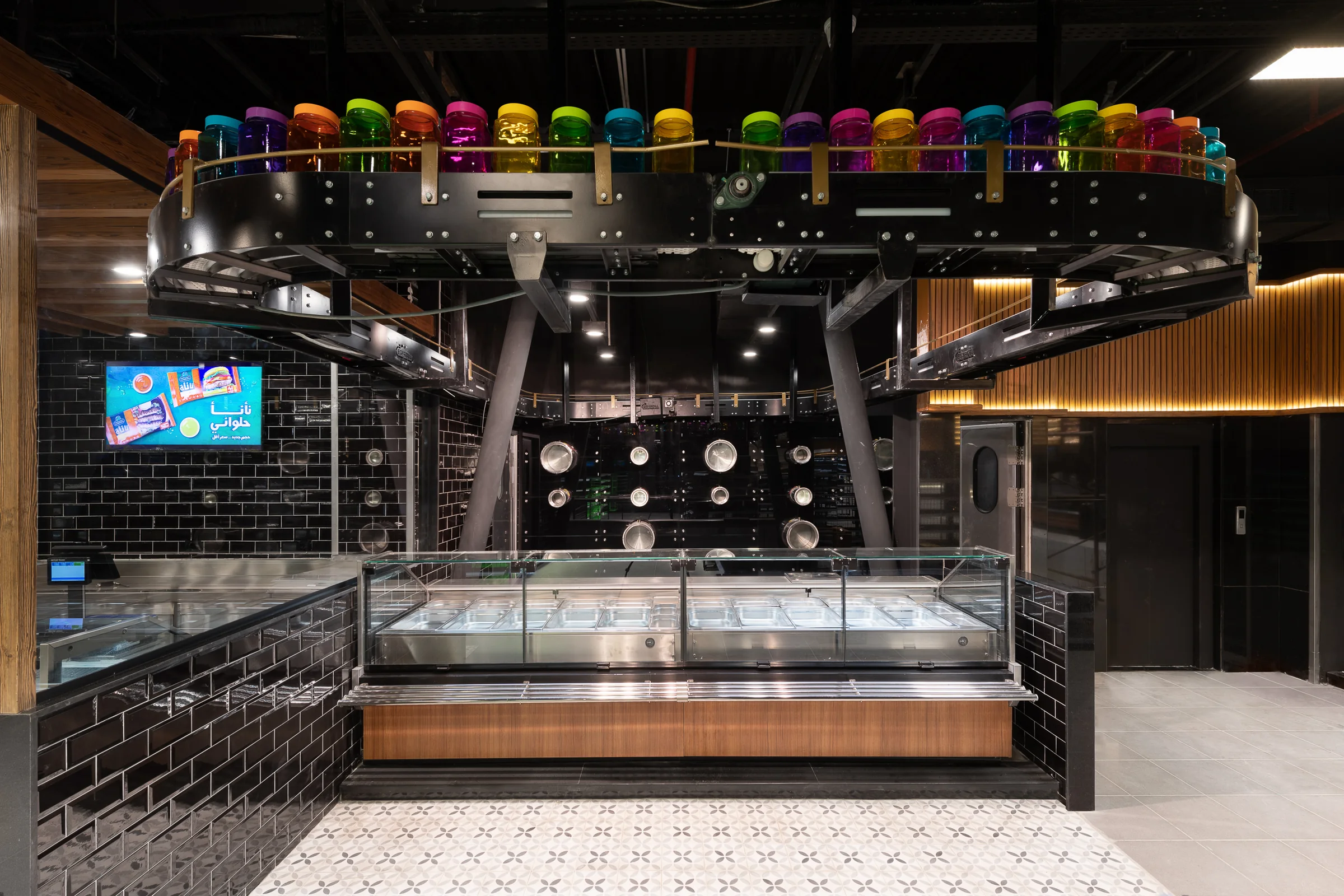 Gelato counter with its bright canisters on a black frame.