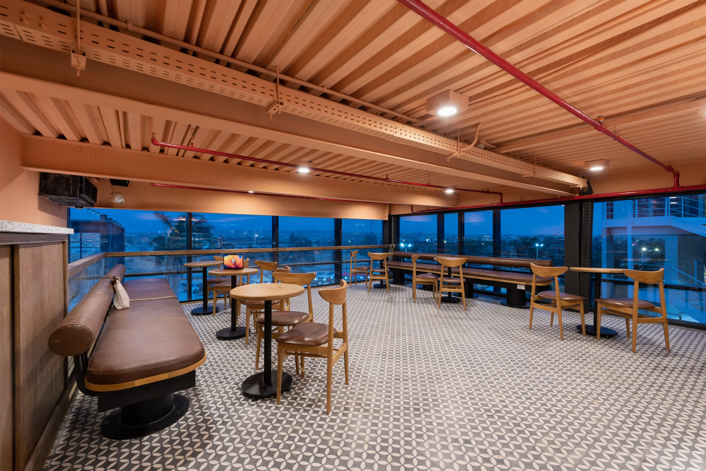 The same seating at dusk, the city beyond the glass.