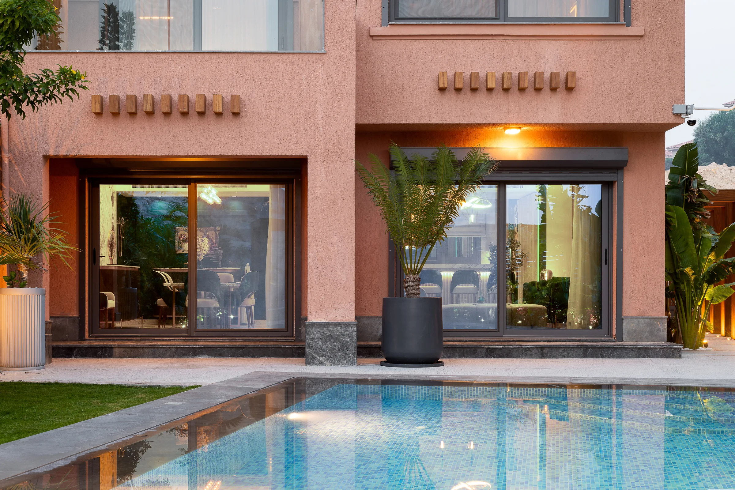 Terracotta render and glazing reflected in the water.
