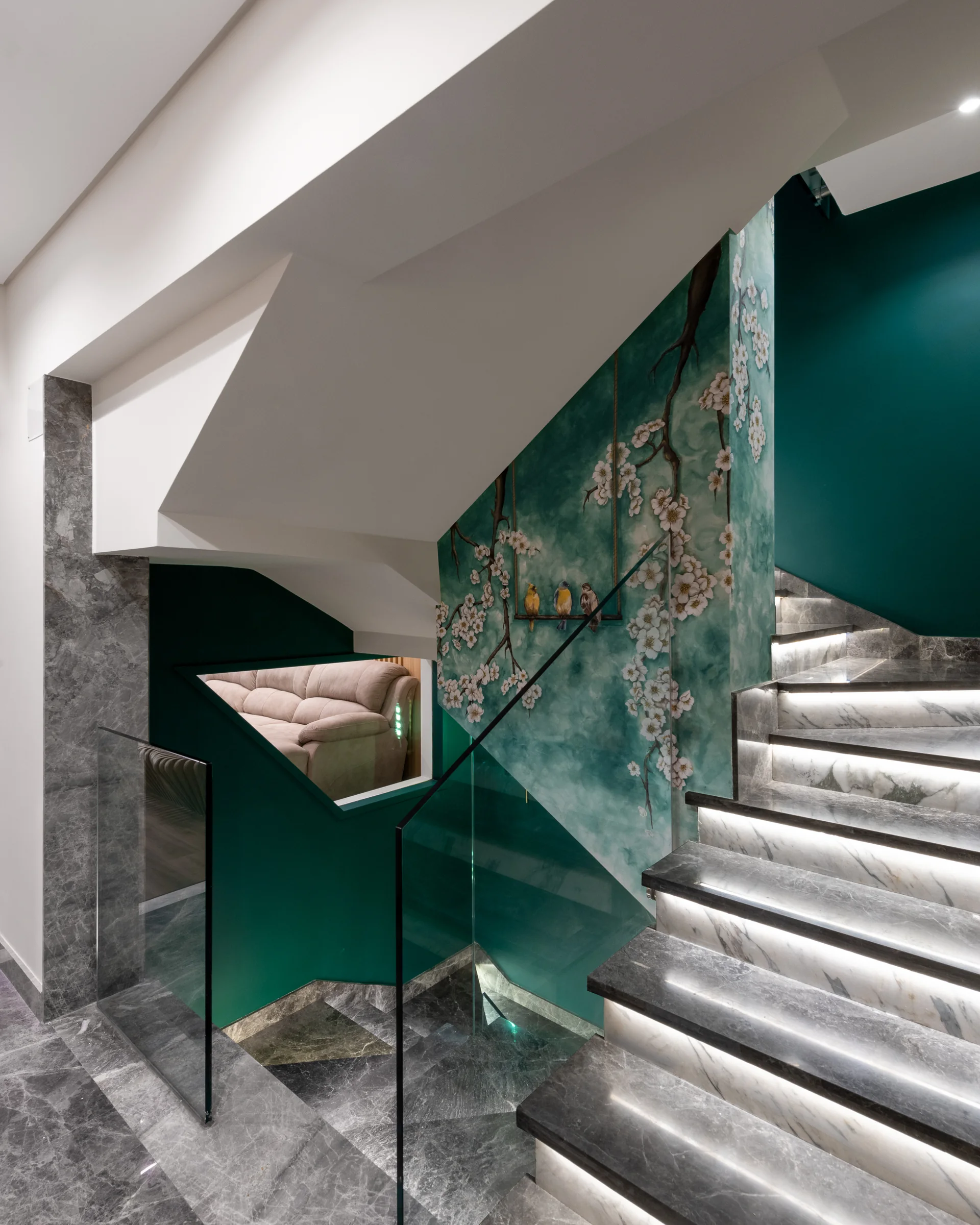 Stair detail: stone tread, glass balustrade, artwork behind.