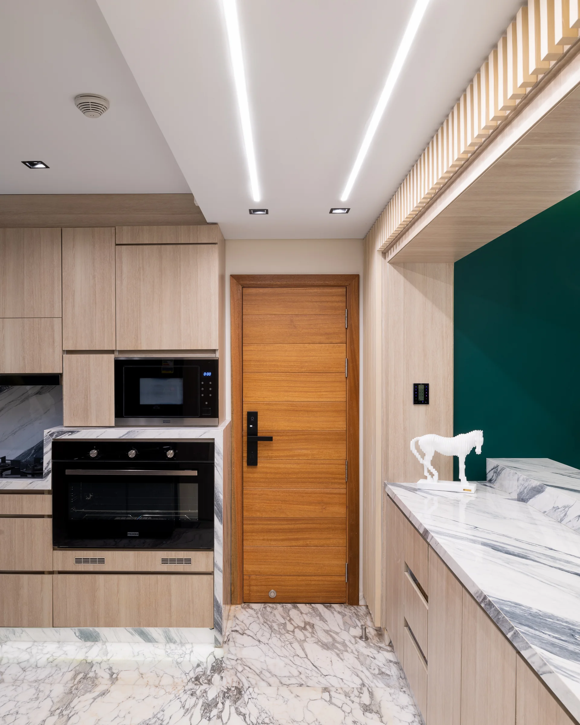 Kitchen detail: oven stack, timber and green.