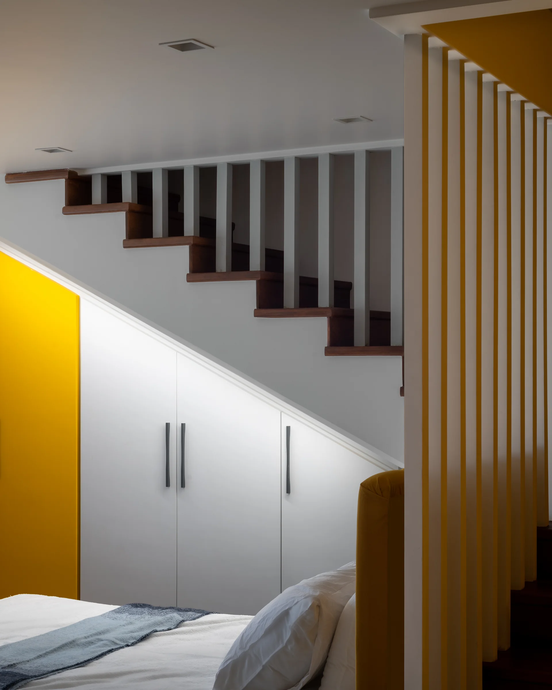 Bedroom with a slatted screen and a yellow press.
