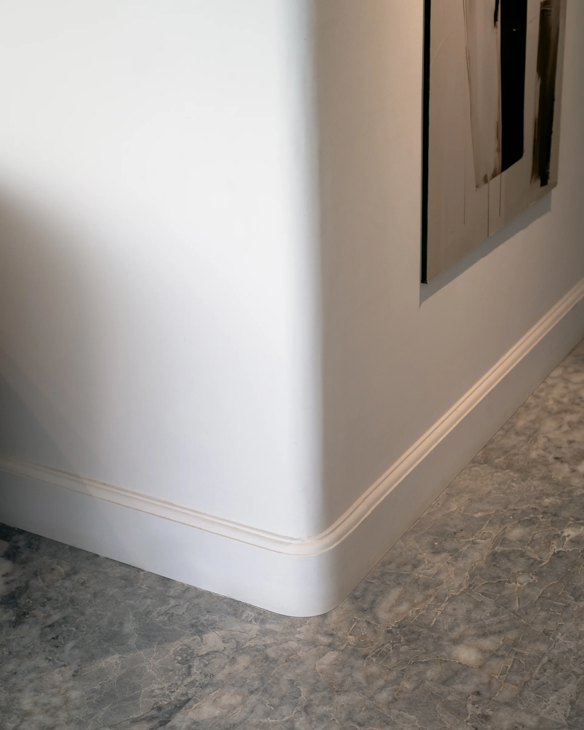 Wall and skirting detail where plaster meets polished stone.