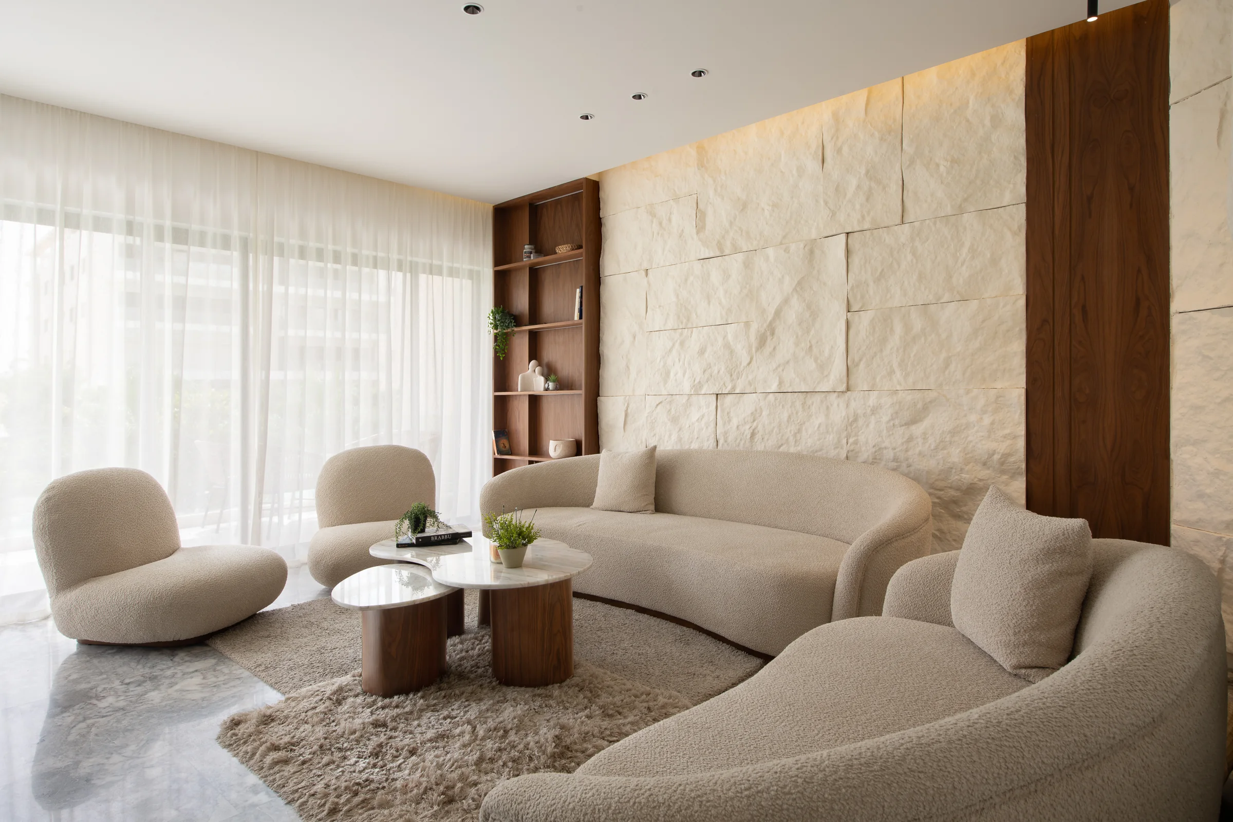 Living room square on, the carved stone wall centred behind the sofa.