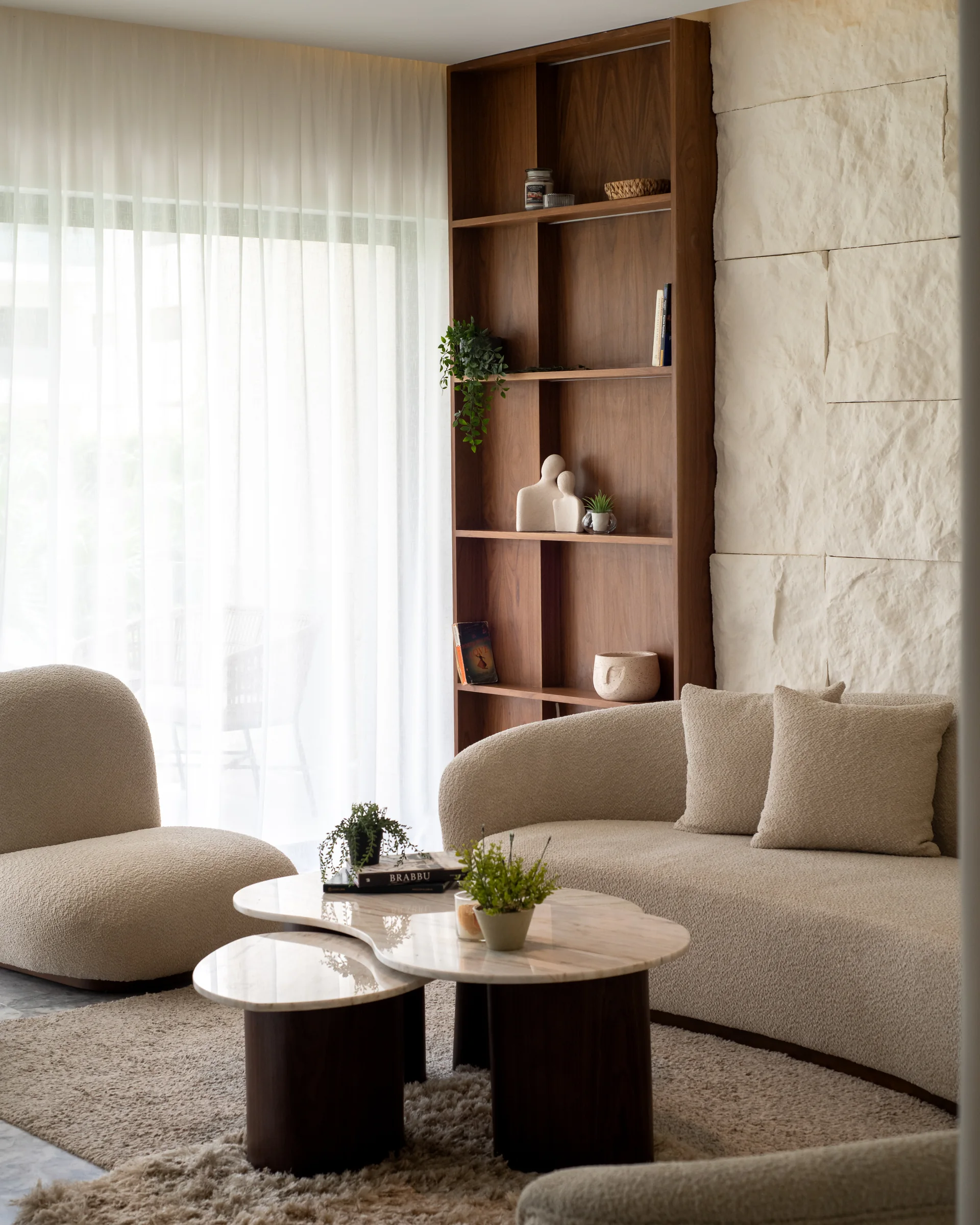 The living room seen over the sofa back, shelving alongside.