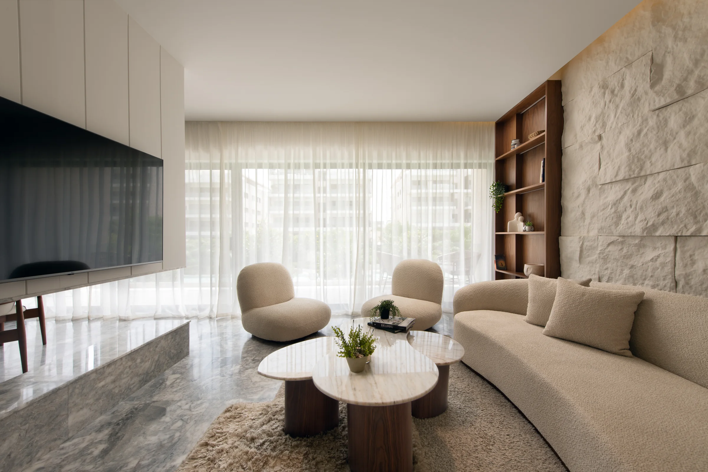 Living room from the television wall, stone table in the foreground.