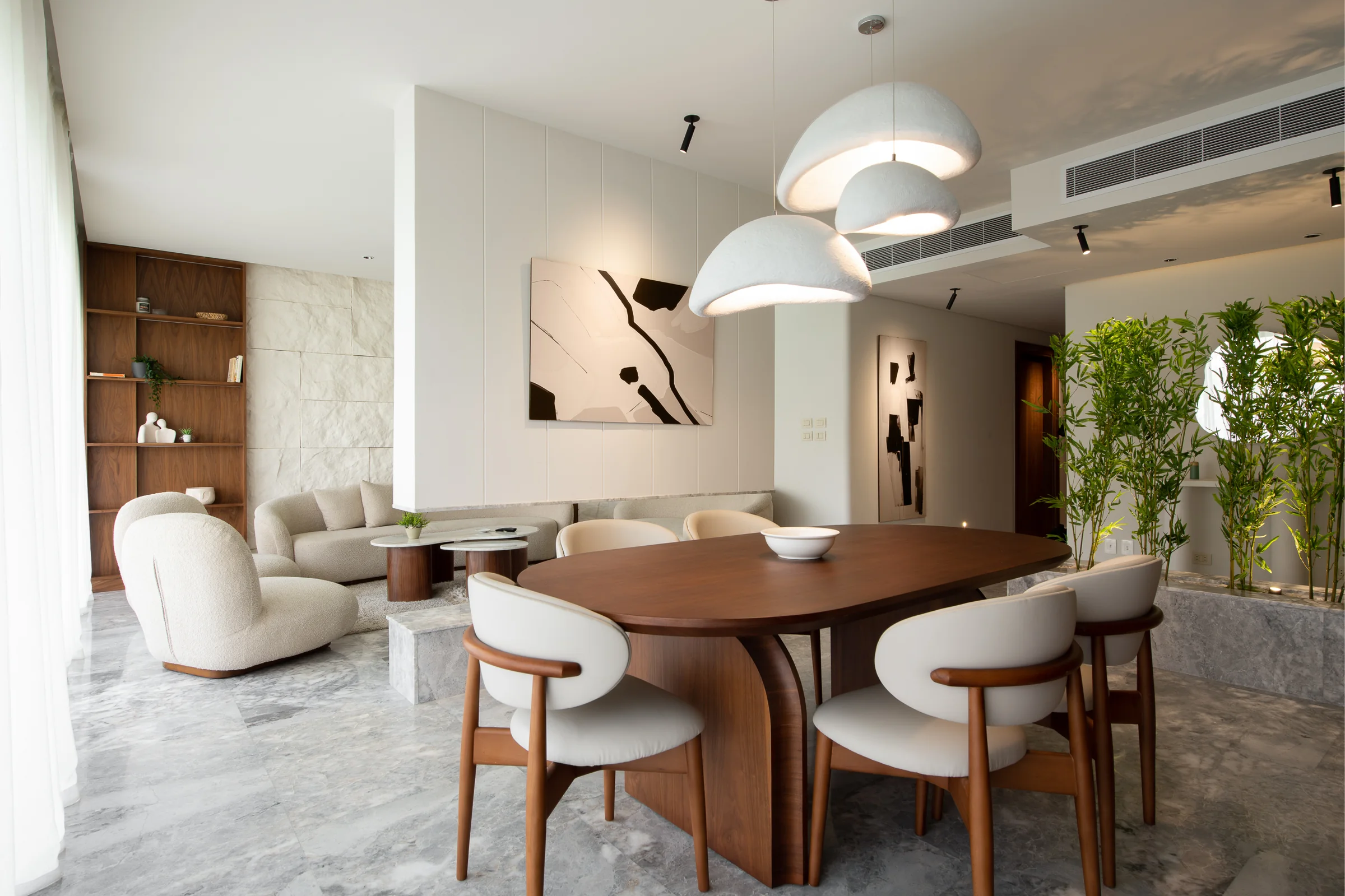 Dining and living together, pendants low over the table.