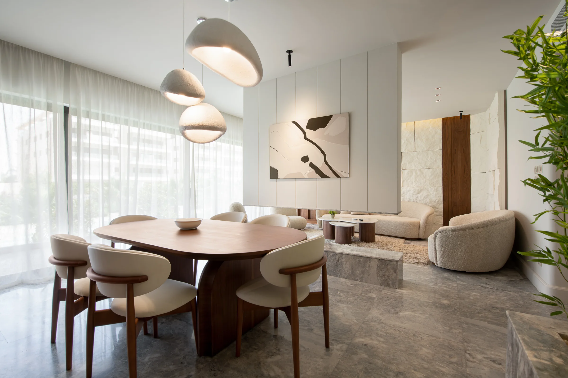 Bright dining room with curved chairs and artwork beyond.