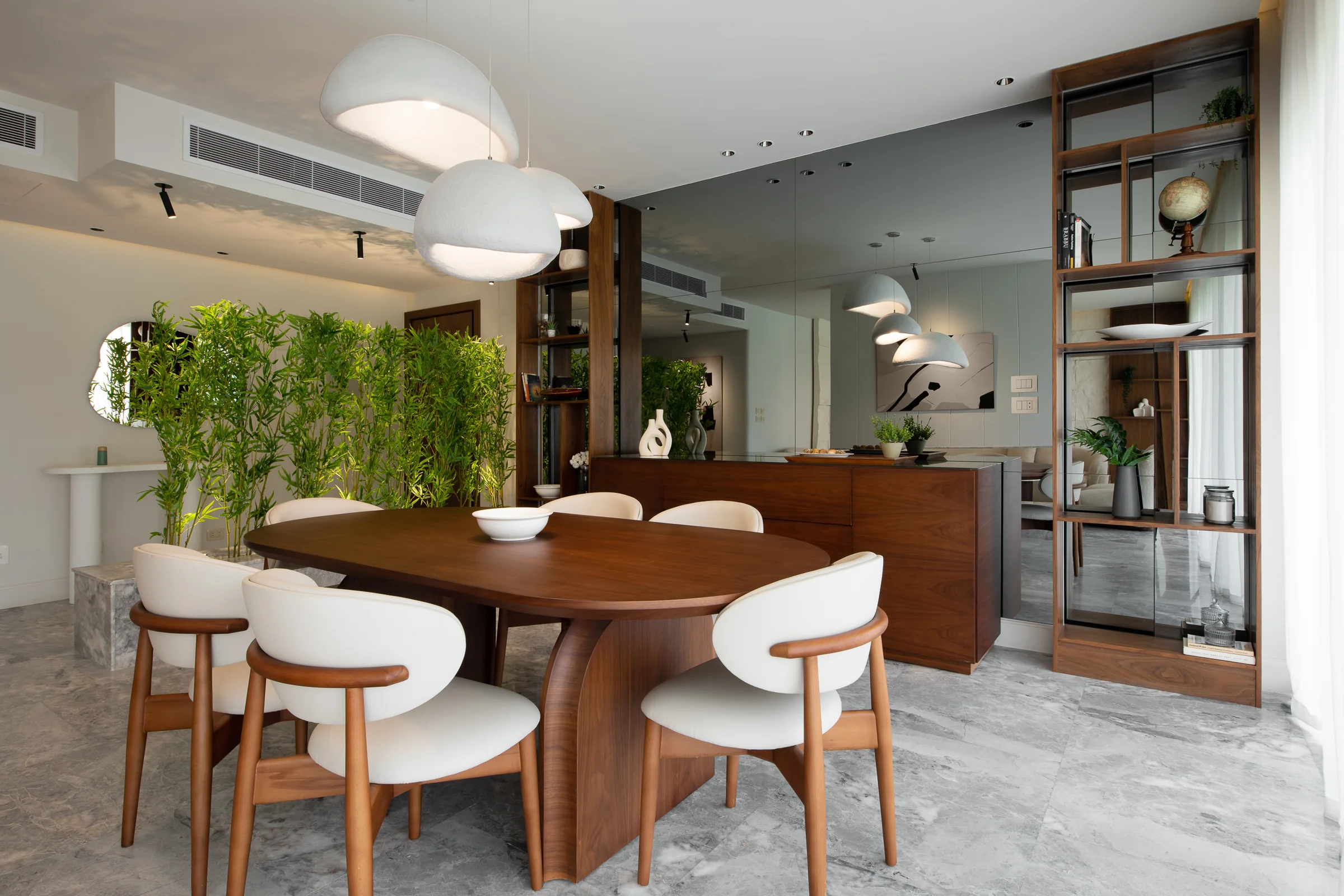 Dining table with the kitchen and a green wall behind.