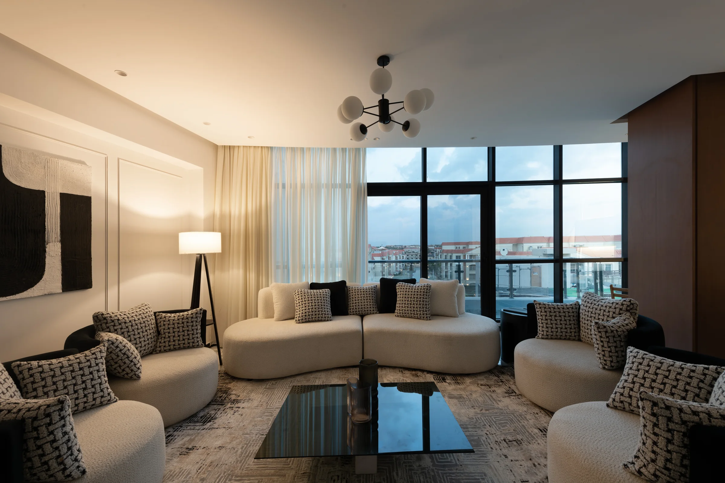 Living room with curved seating and the city framed in the window.