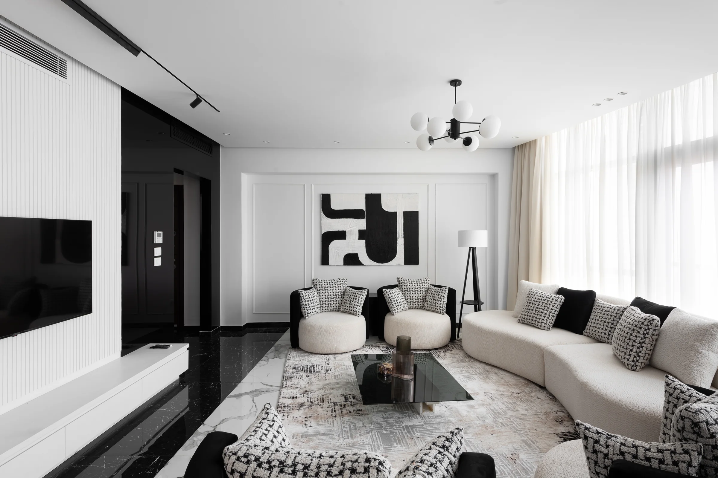 Seating group under a sputnik pendant, monochrome artwork behind.