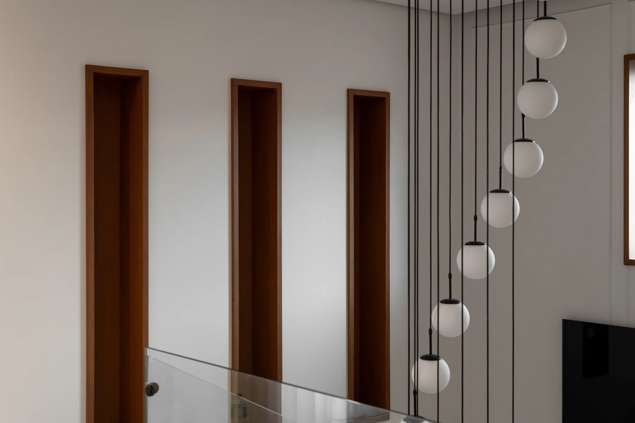 Hall of walnut doors with a cascade of glass spheres.