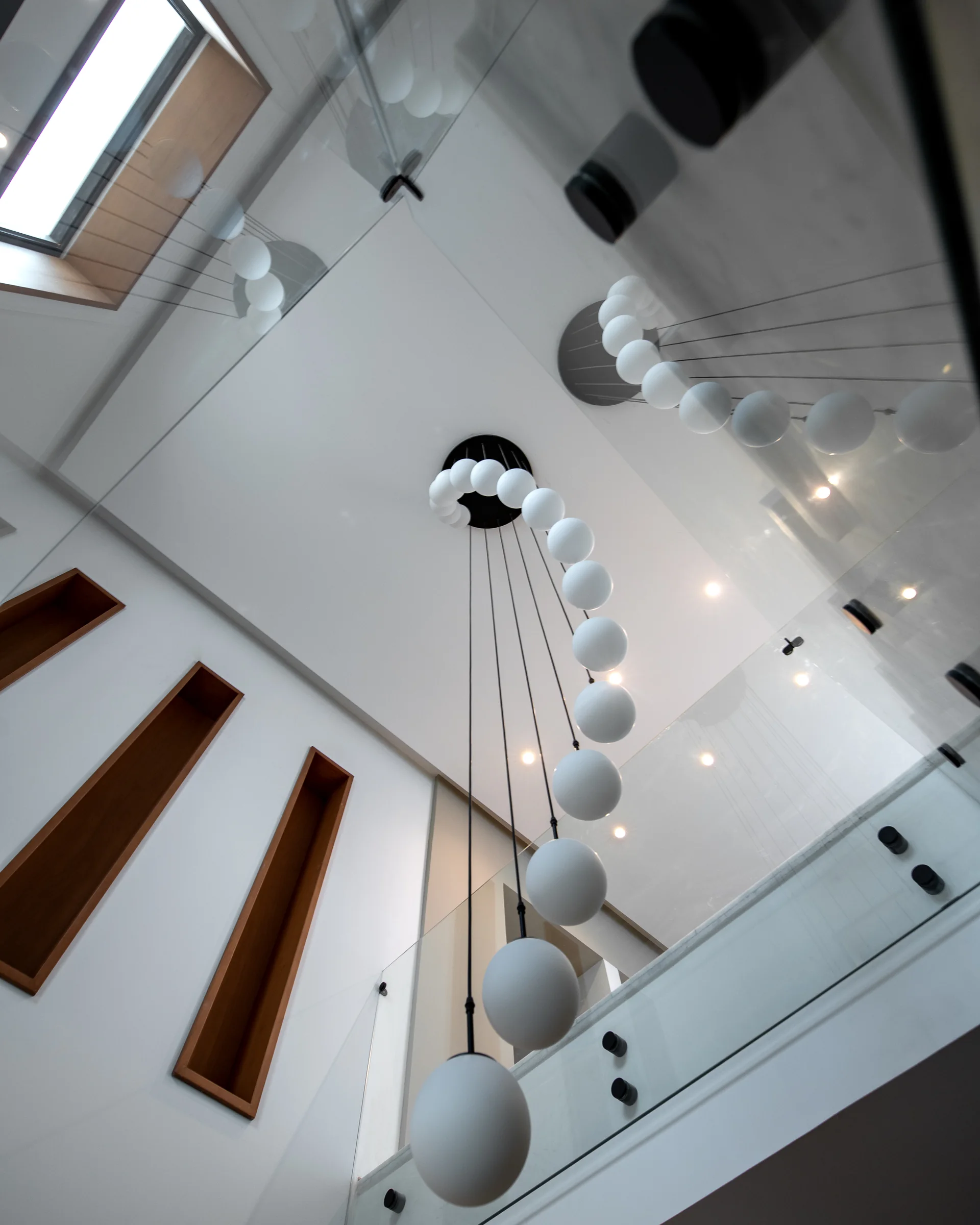 Looking up the stair void at the pendant cascade.