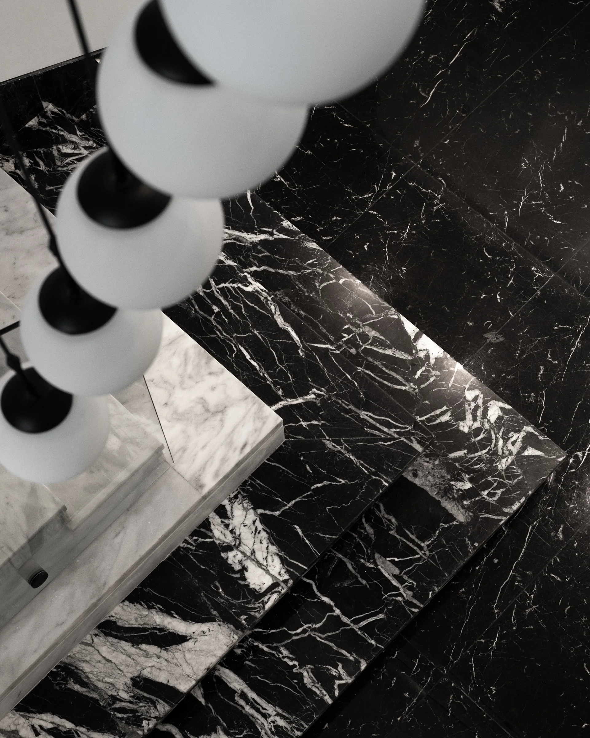 Glass spheres over black marble, seen from above.
