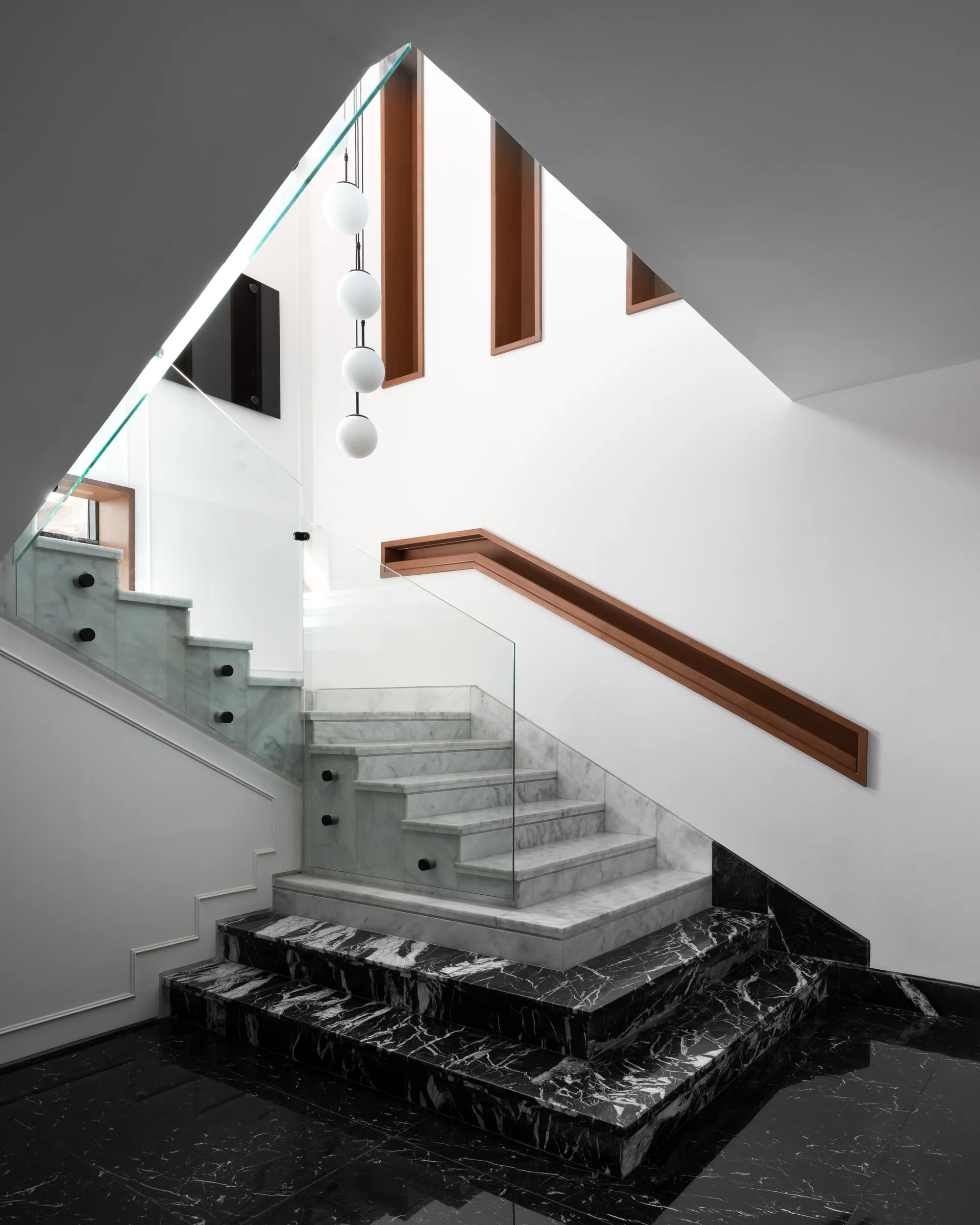 The stair from below, treads folding into the void.