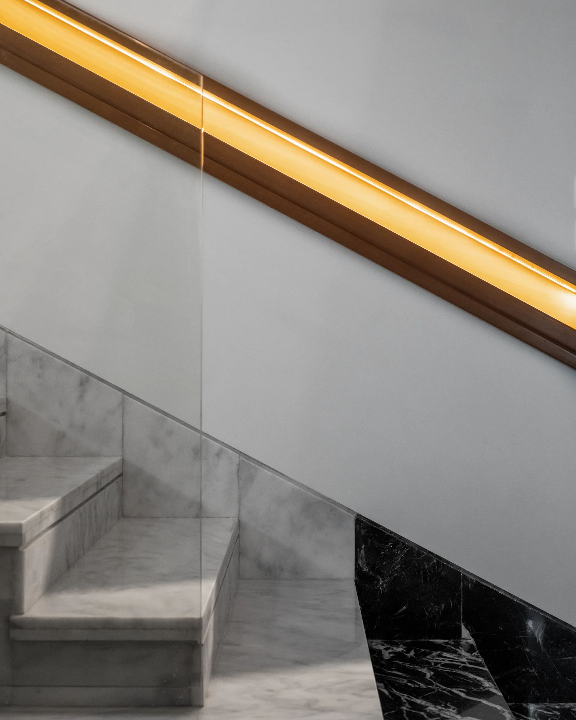 Stair detail: stone tread meeting a brass reveal.