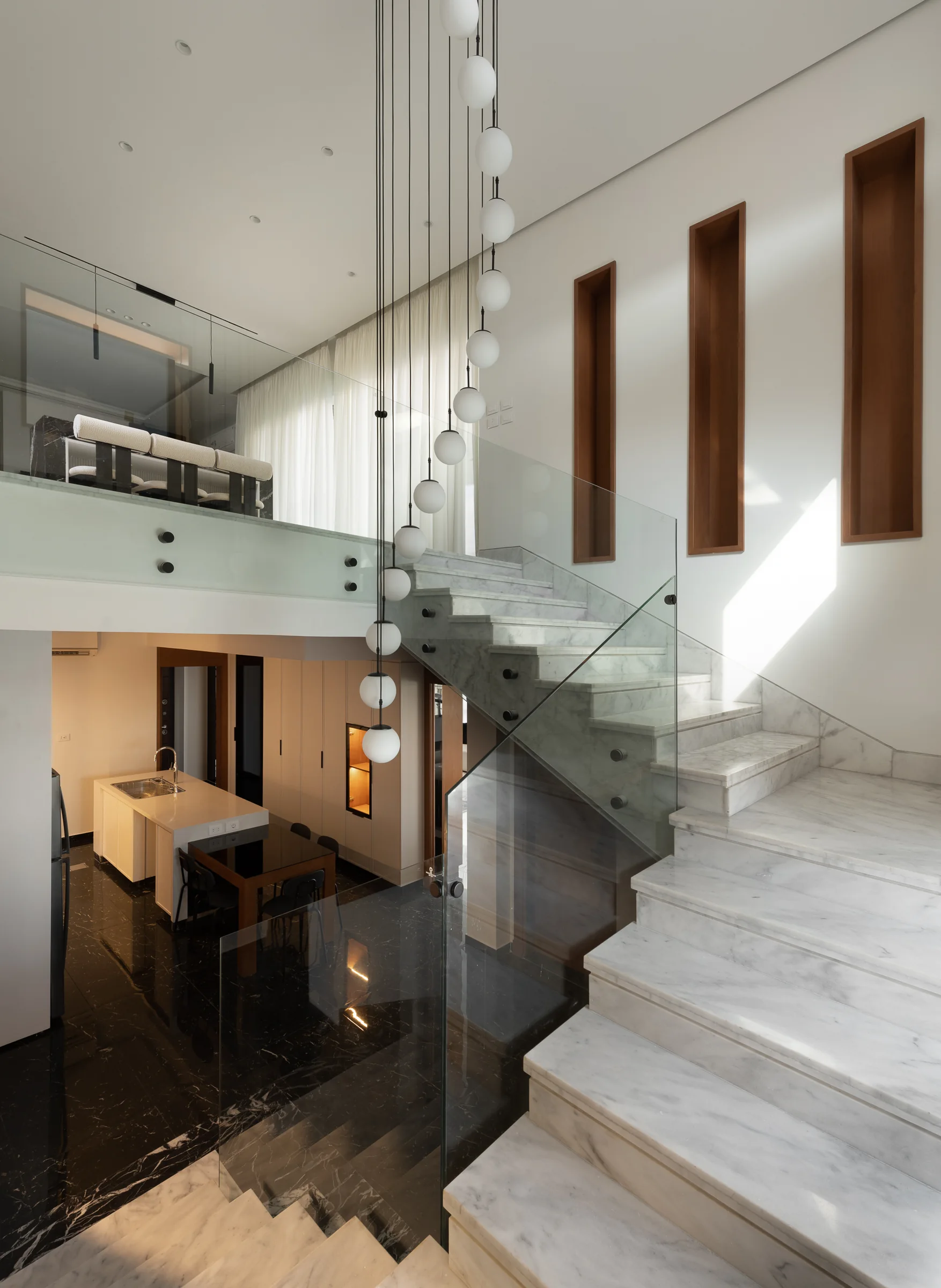 The stair with the dining room beyond the glass.