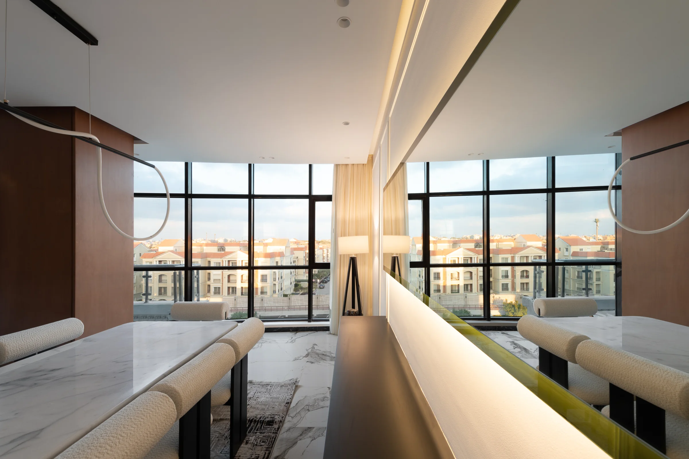 Dining room along the window wall, rooftops beyond.