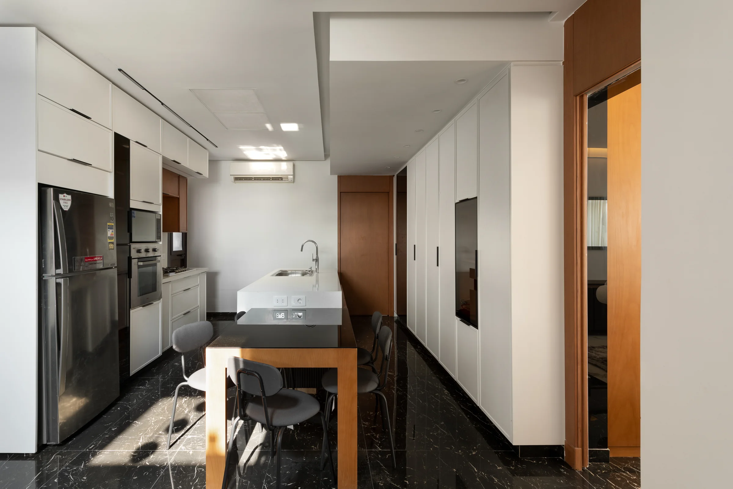 Kitchen wide: island, tall units and the corridor beyond.
