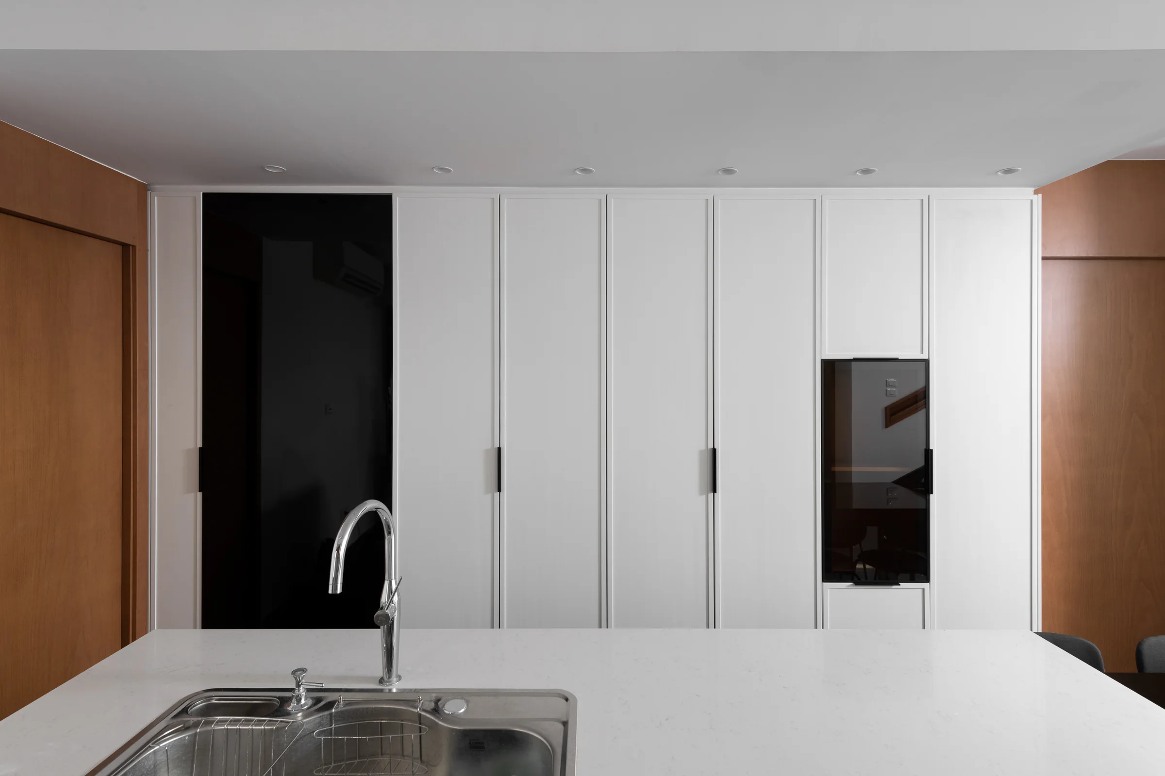 Kitchen sink run against full-height white units.