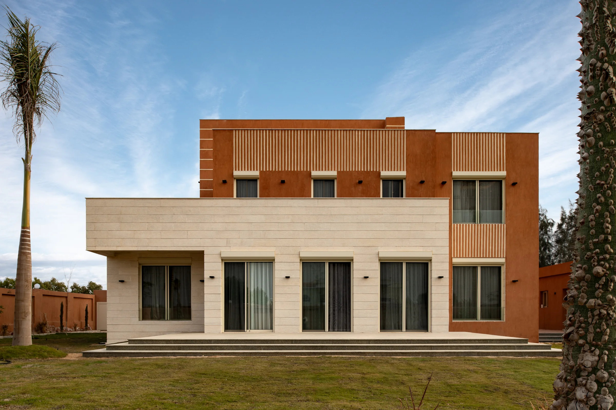 The full garden elevation: limestone base, terracotta upper storey, louvred screen.