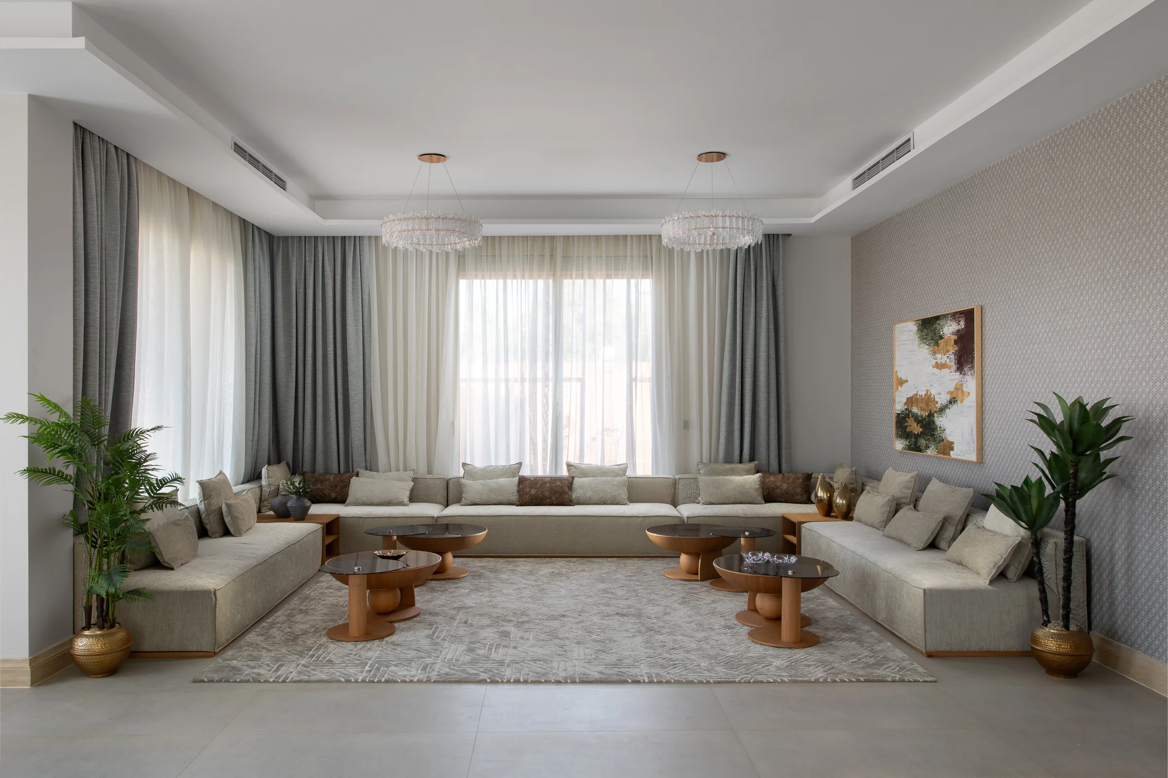 Symmetrical living room with modular sofas and full-height sheer curtains.