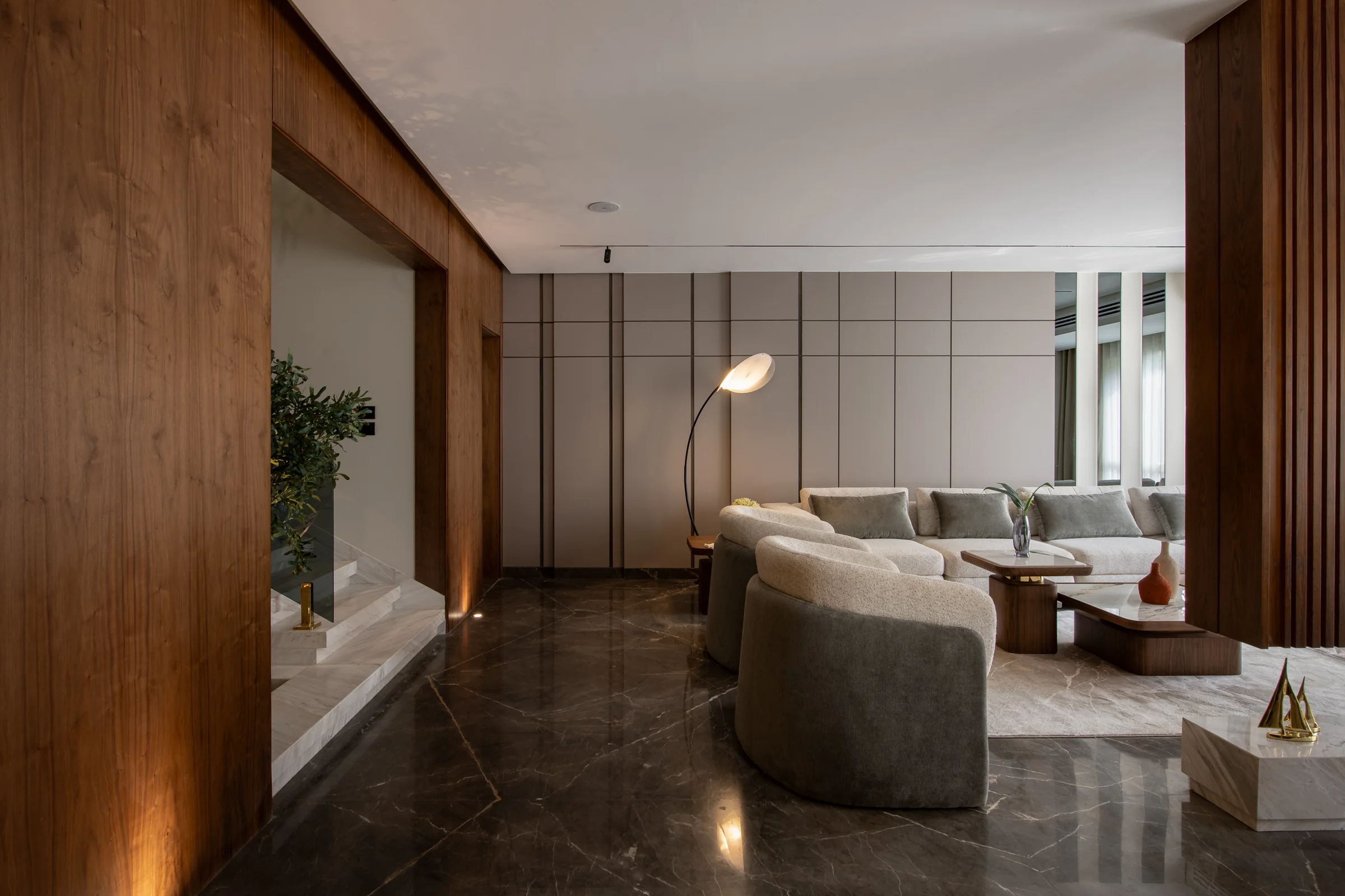 Long living room over dark polished marble, timber panels framing the view.