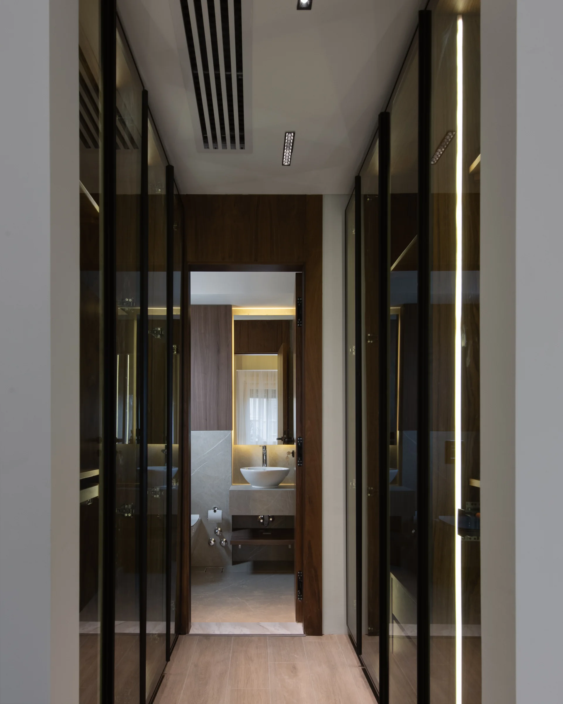 Dark corridor lined with glazed steel doors.