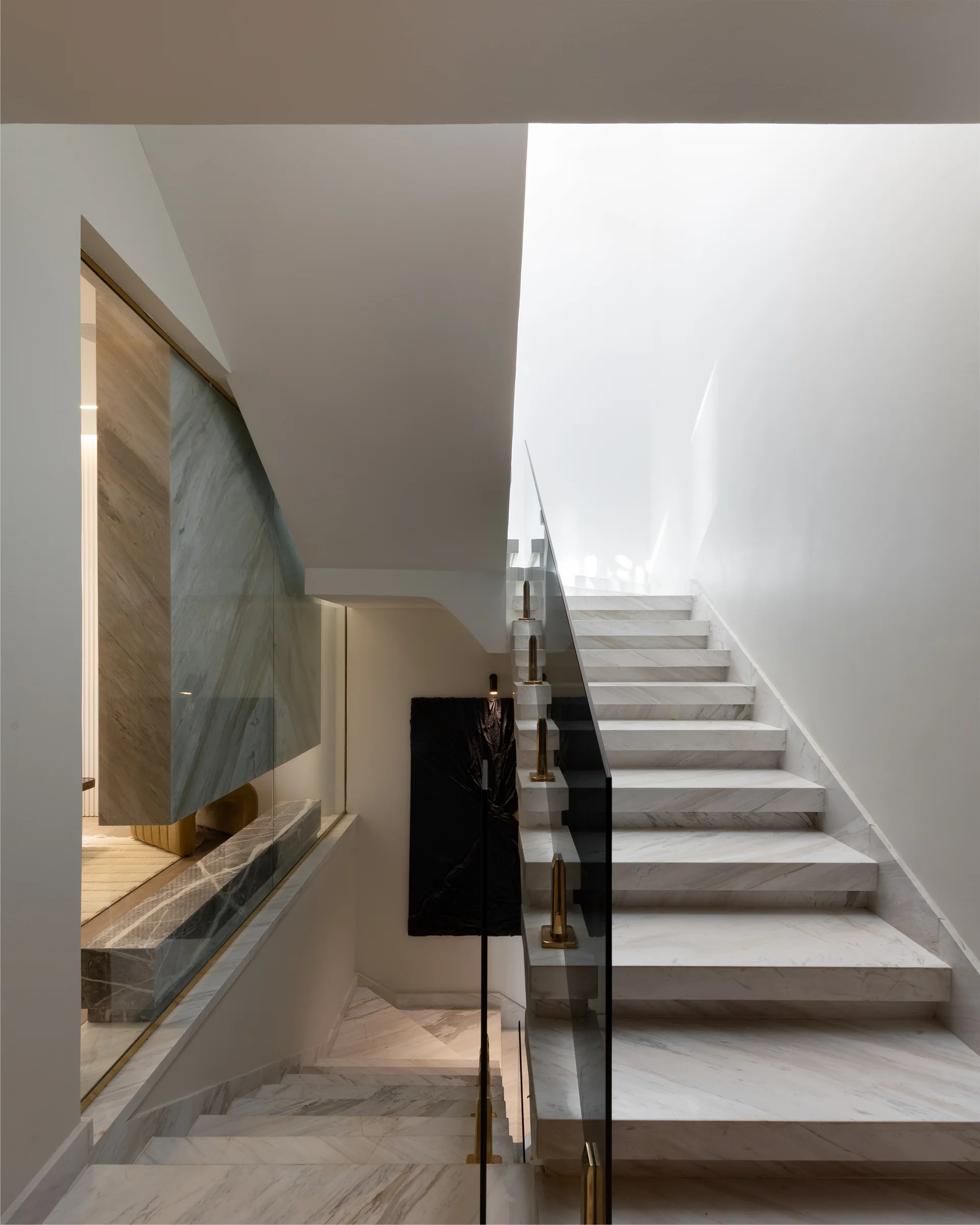 Stair flight rising past a stone-topped console.