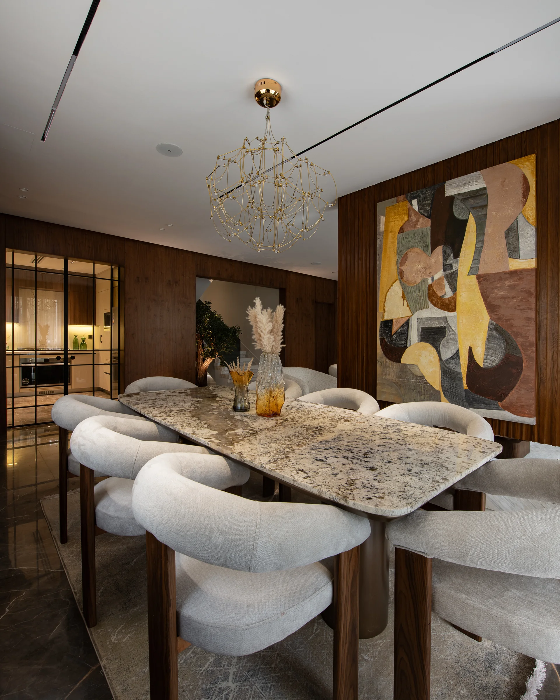 Marble dining table and curved chairs, seen along its length.