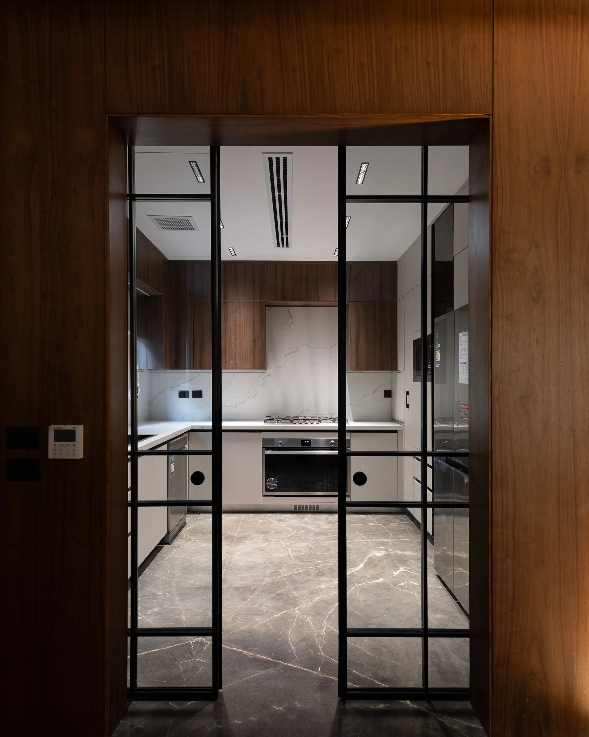 Kitchen behind closed glazed steel doors.