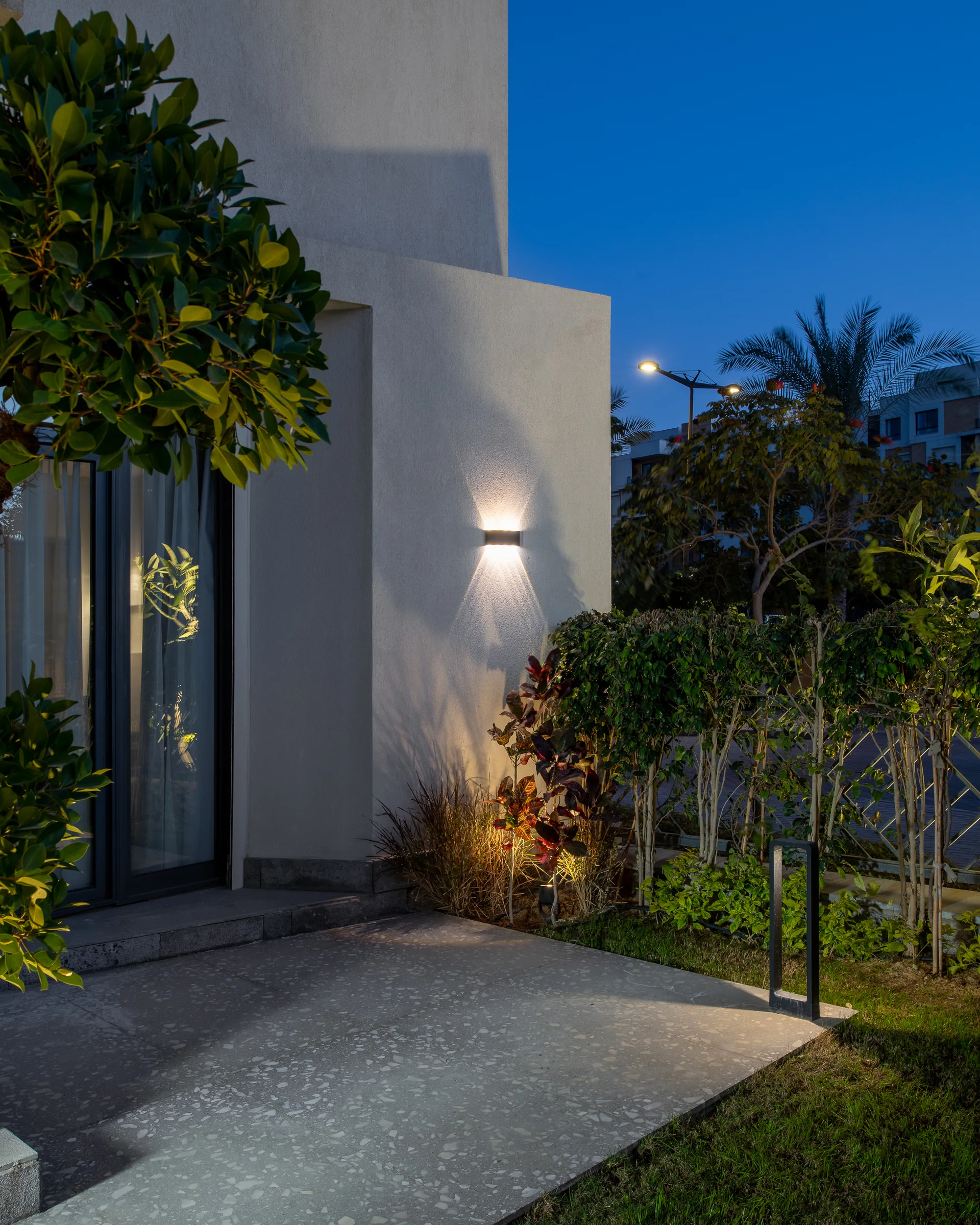 The entrance at dusk, render and planting lit from below.