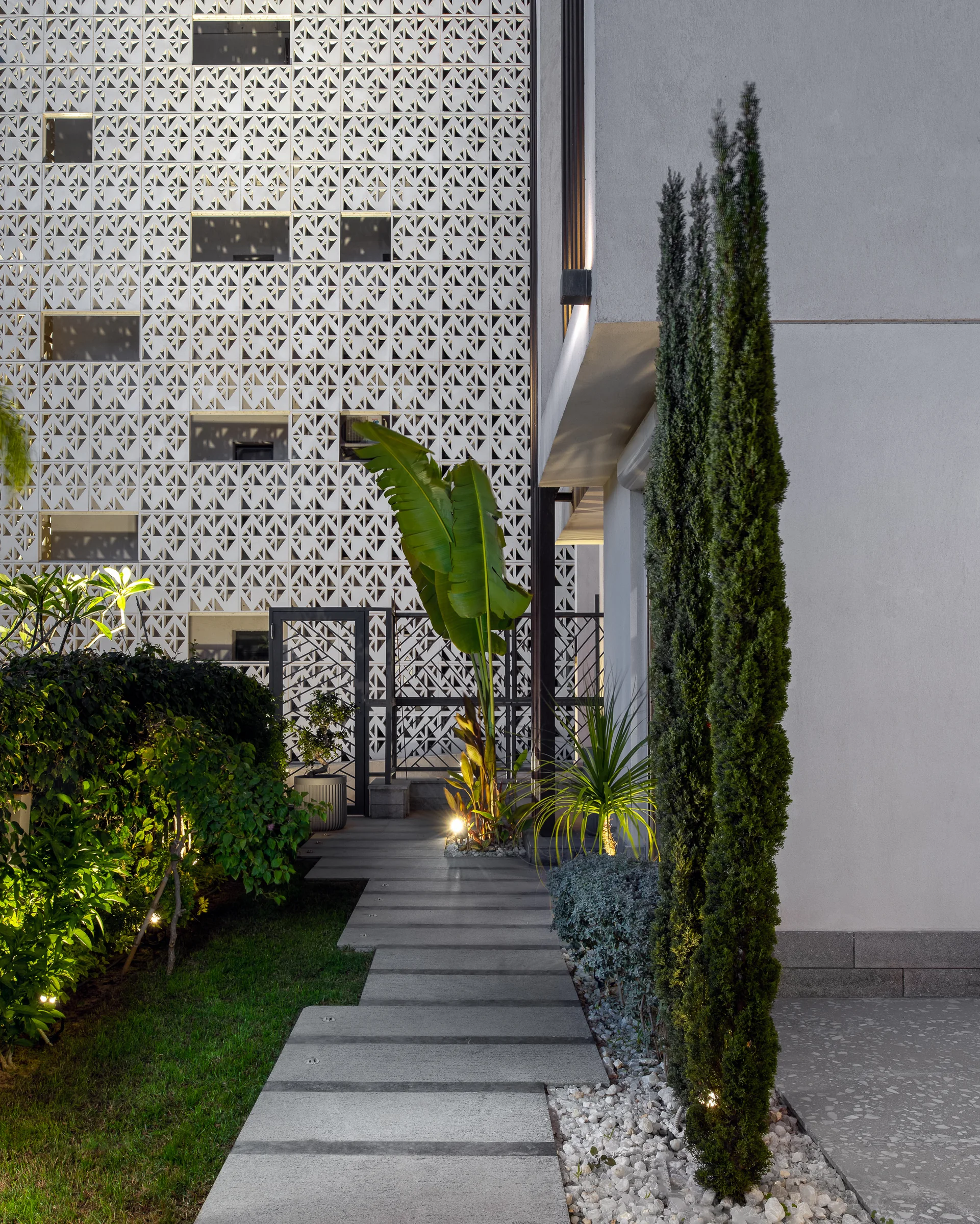 The screen wall from the path, cypress against render.