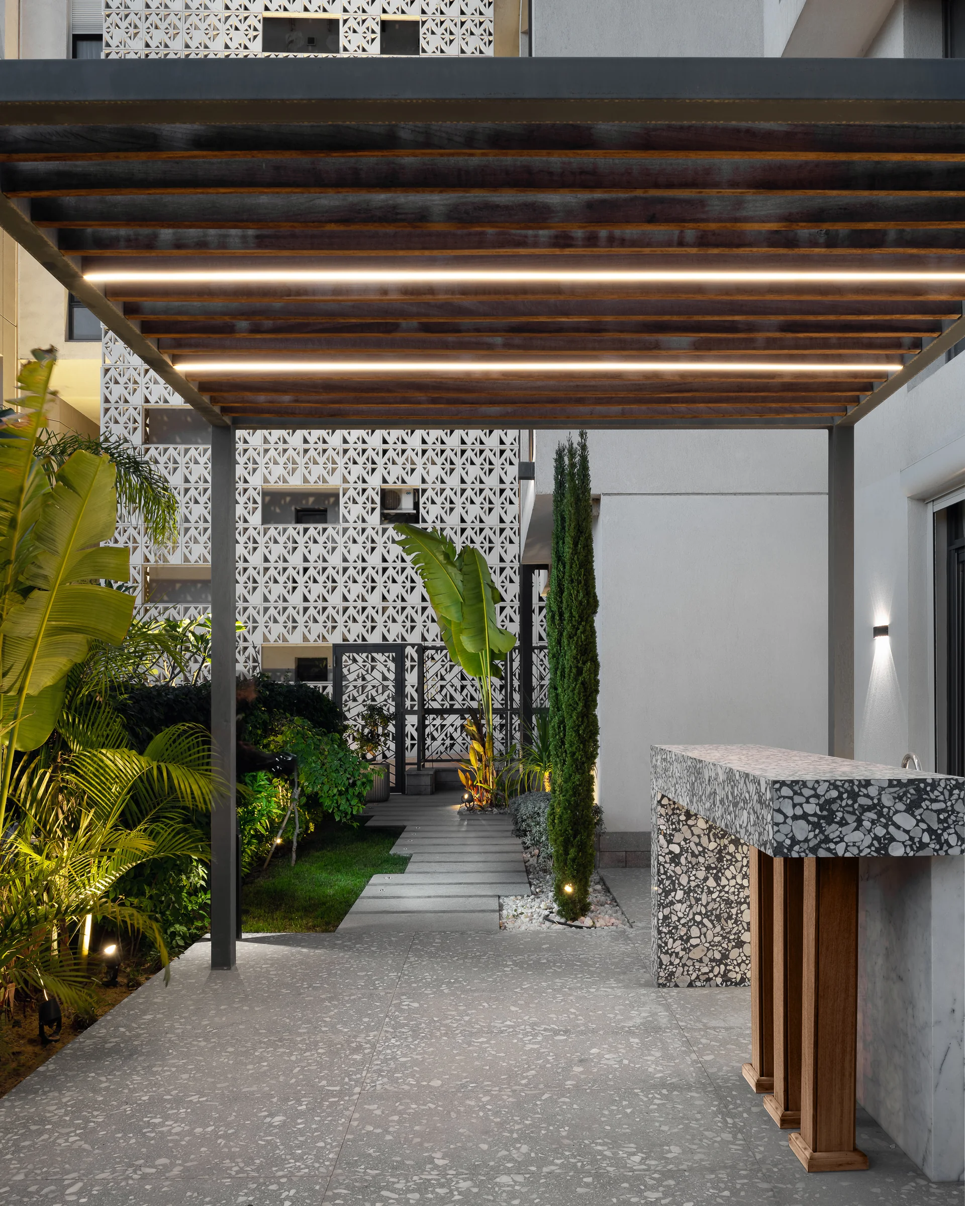 Under the pergola: terrazzo counter, banana palm, gravel.