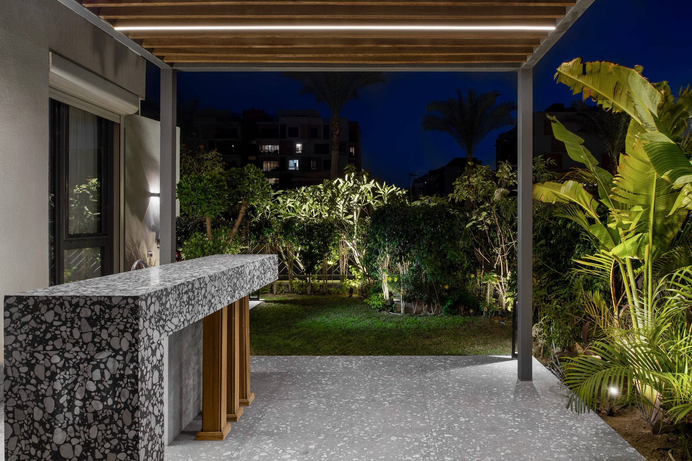 Night in the courtyard, the counter and the garden lit.