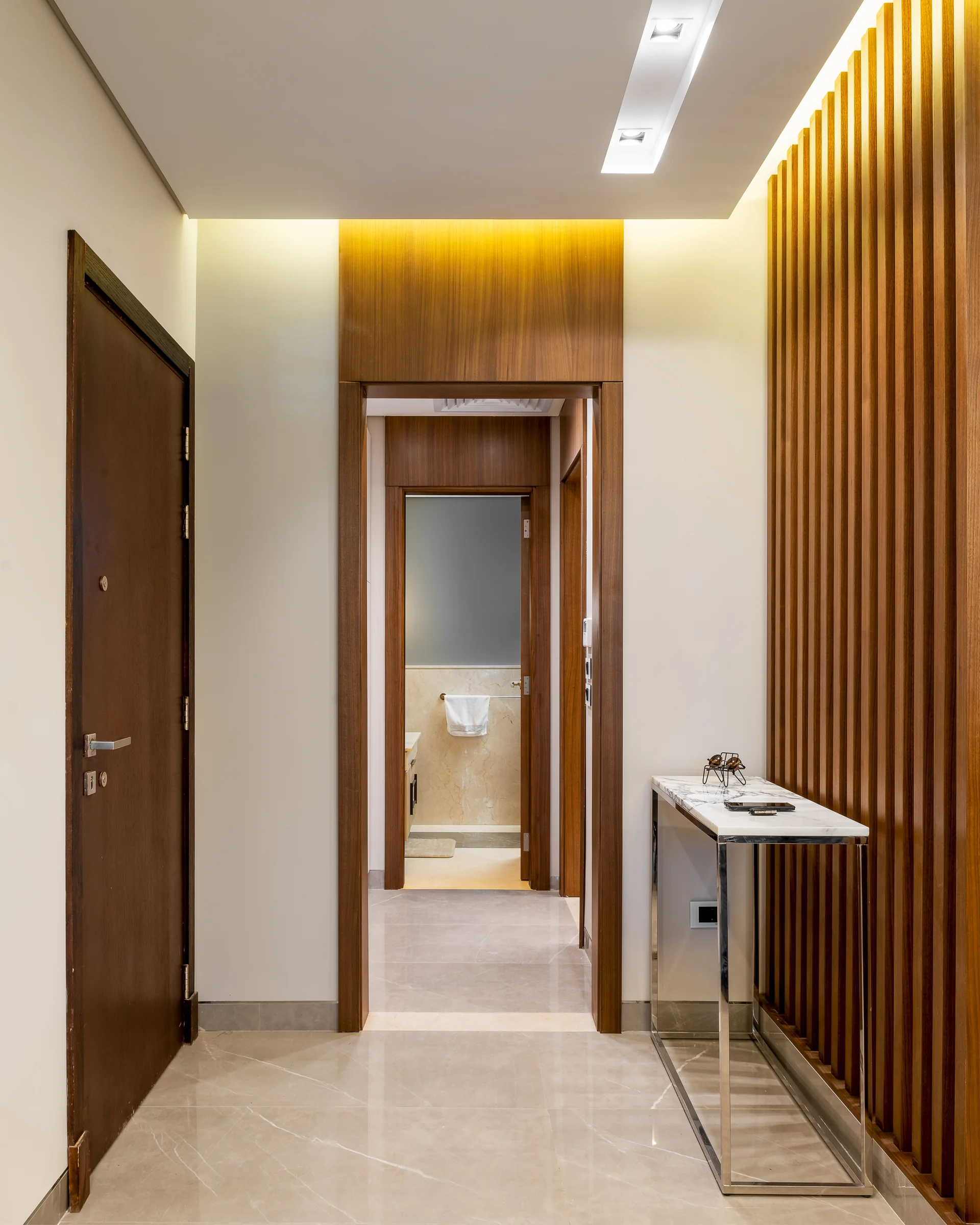 Entrance corridor in walnut, cove light along the ceiling.
