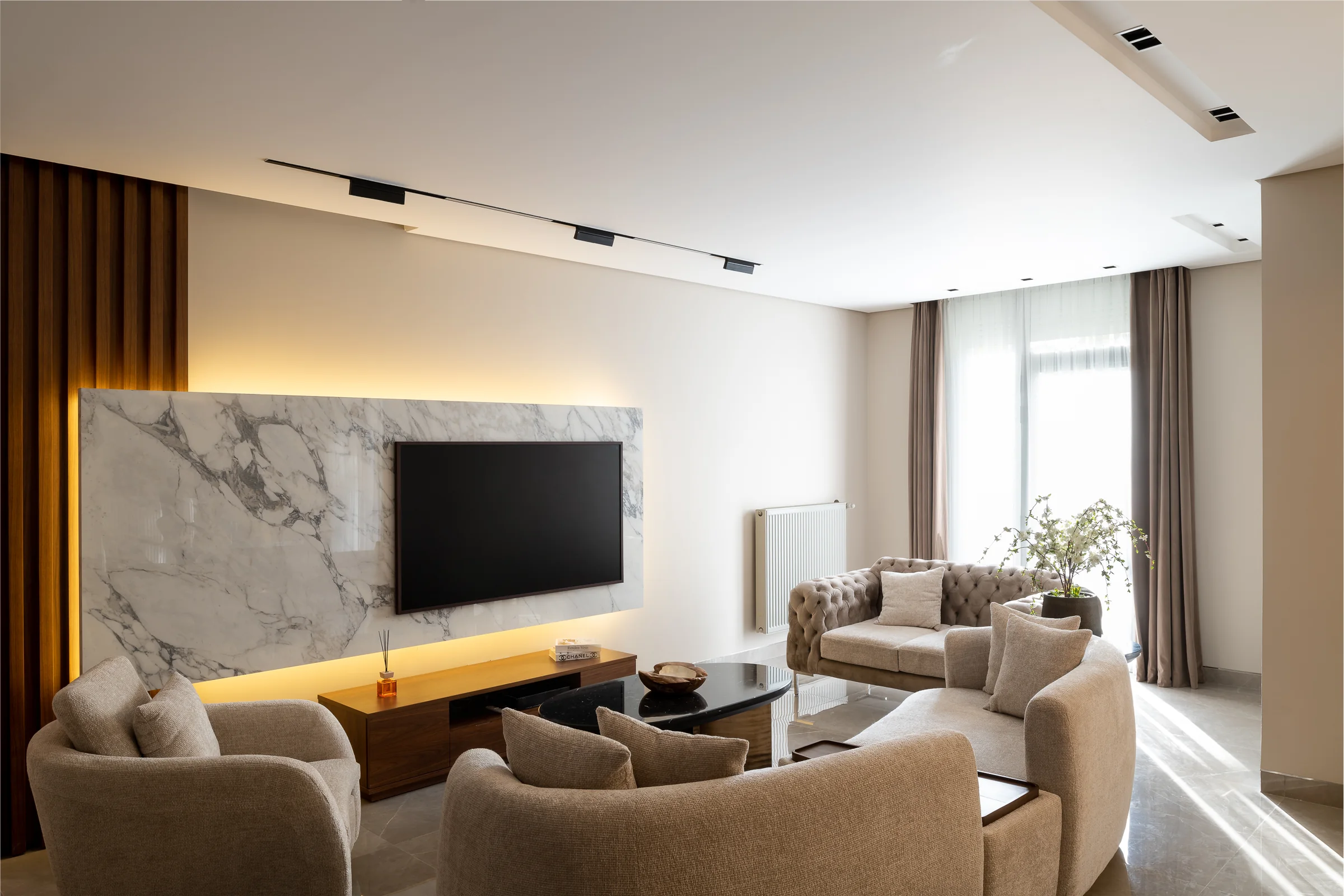 The media wall from the seating, marble framed in walnut.
