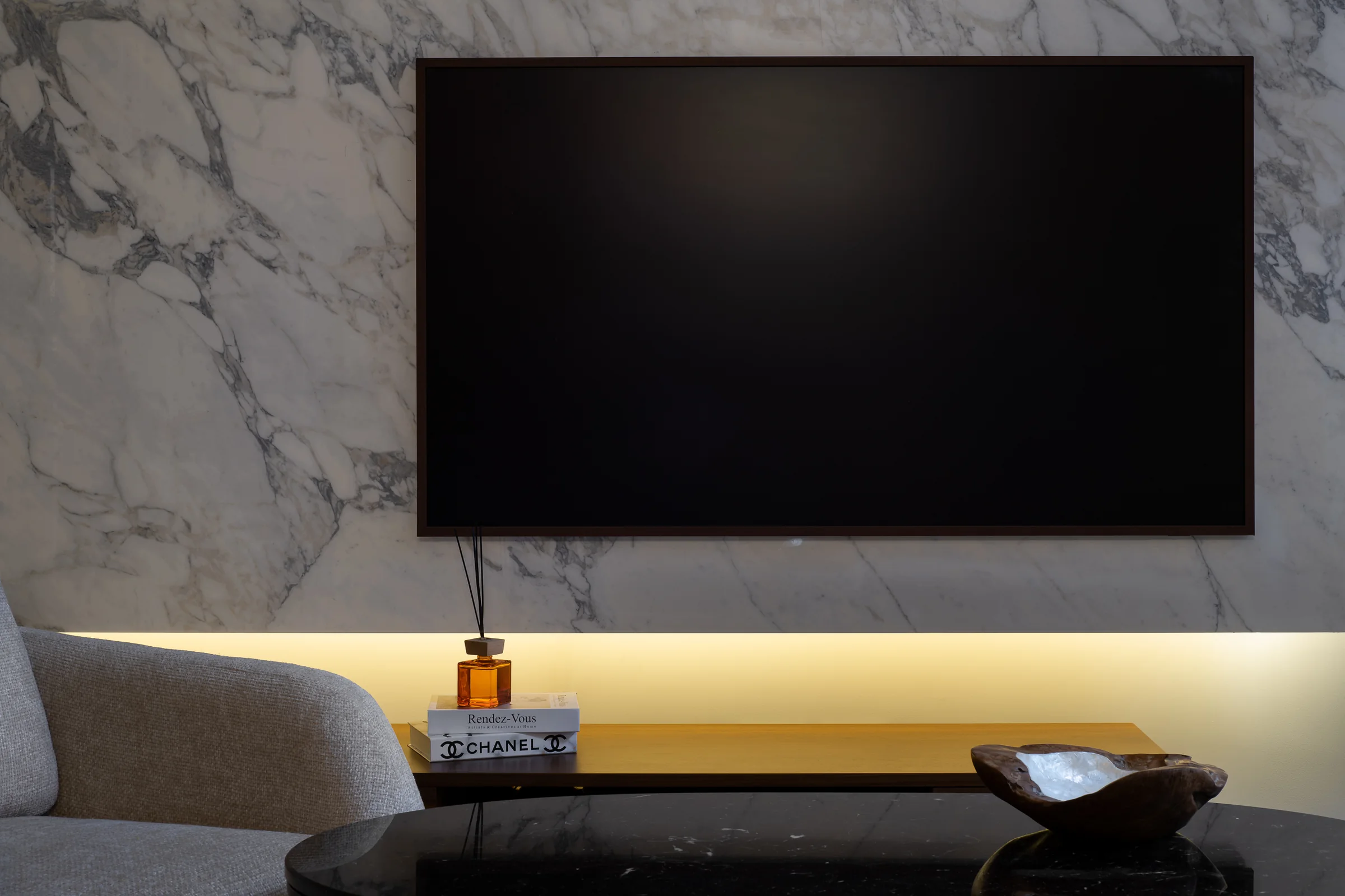 Marble and walnut behind the screen, lit from within.